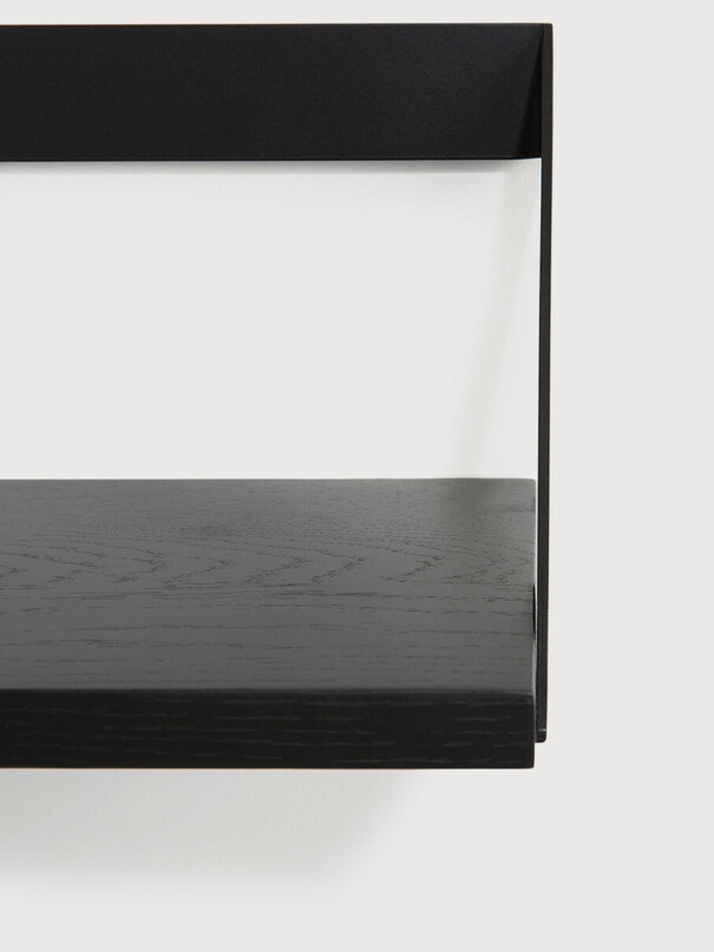 Ethnicraft Ribbon Shelf, a sleek modern minimalist wall shelf featuring a rich black stained oak wood shelf with a visible wood grain texture, supported by a clean matte black metal bracket. This contemporary black floating shelf offers a sophisticated design, perfect for elegant shelf styling in a living room, bedroom, or home office.