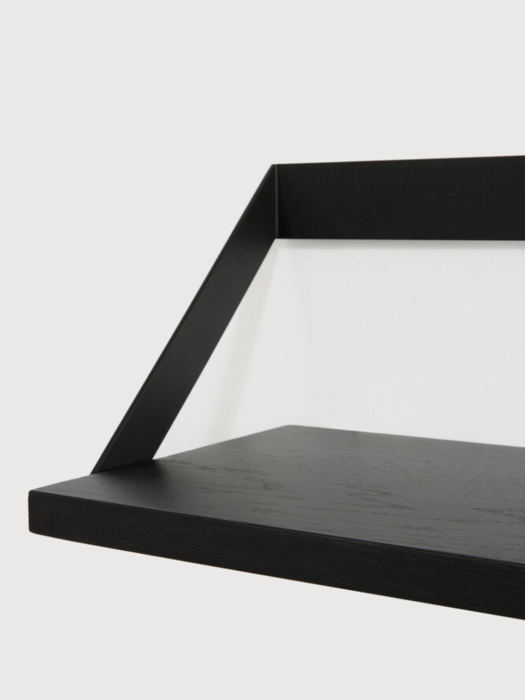 Ethnicraft Ribbon Shelf, a modern minimalist black oak wall shelf featuring a sleek solid wood plank with a subtle wood grain and a unique matte black metal bracket with an angled ribbon design. Ideal for contemporary living rooms, minimalist bedrooms, or stylish home office display and storage.