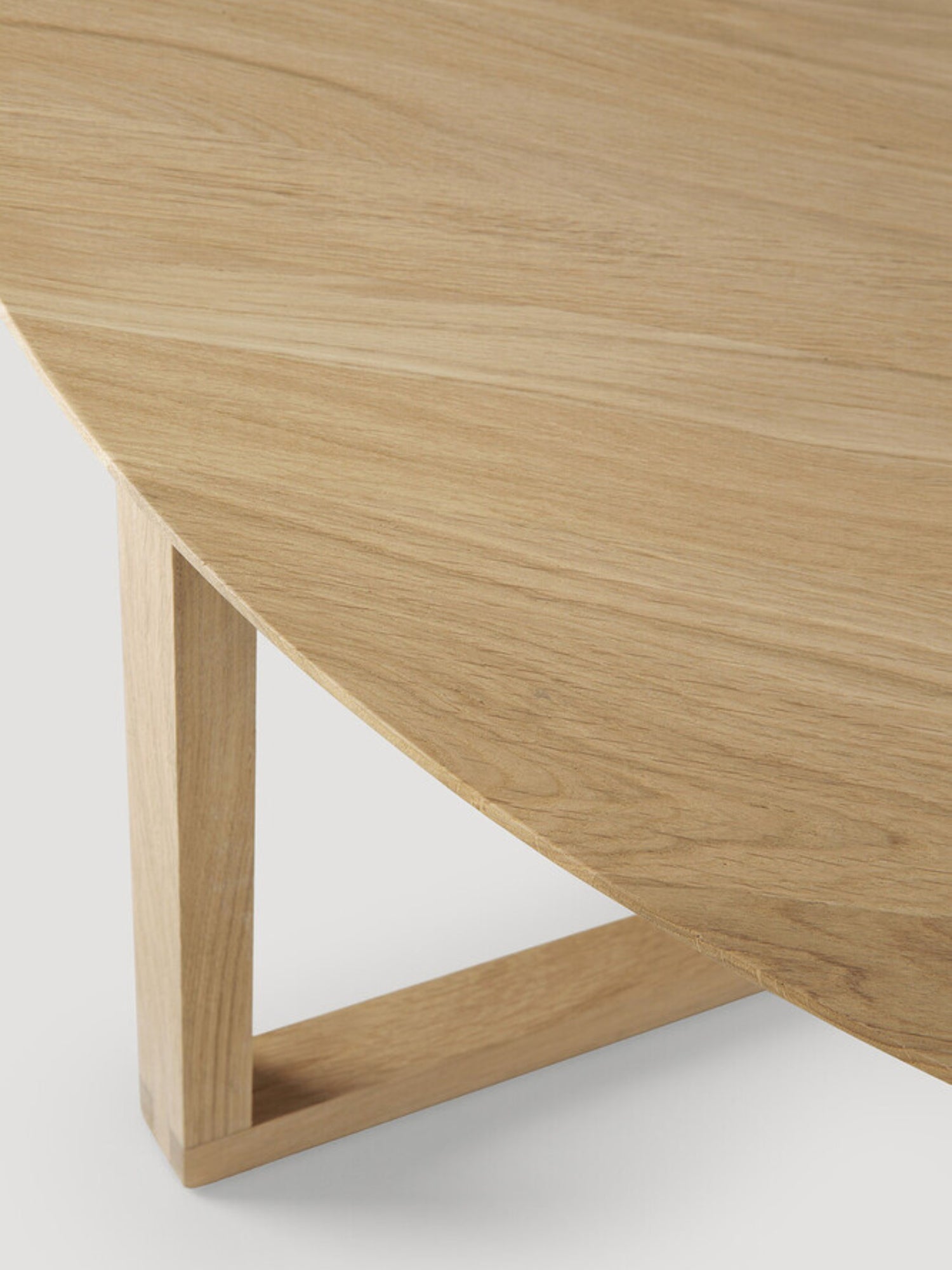 Ethnicraft Tripod Coffee Table, a minimalist round oak coffee table with a smooth, light natural wood surface and visible grain, highlighting the unique angled leg structure on a white background.