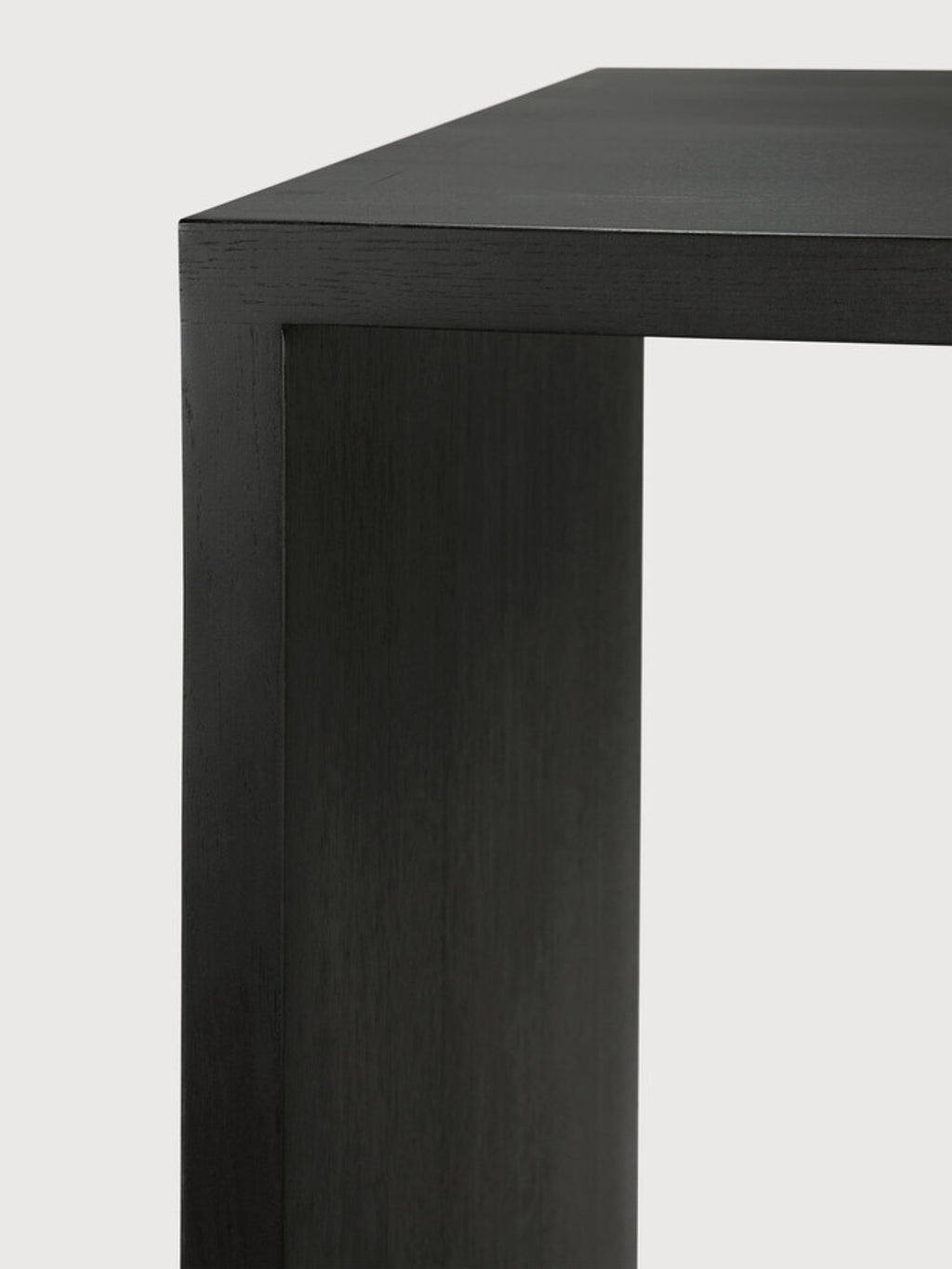 Ethnicraft U Desk, a modern black oak desk, showcasing a close-up of its sleek, dark wooden corner and sturdy construction, displayed on a clean white background.