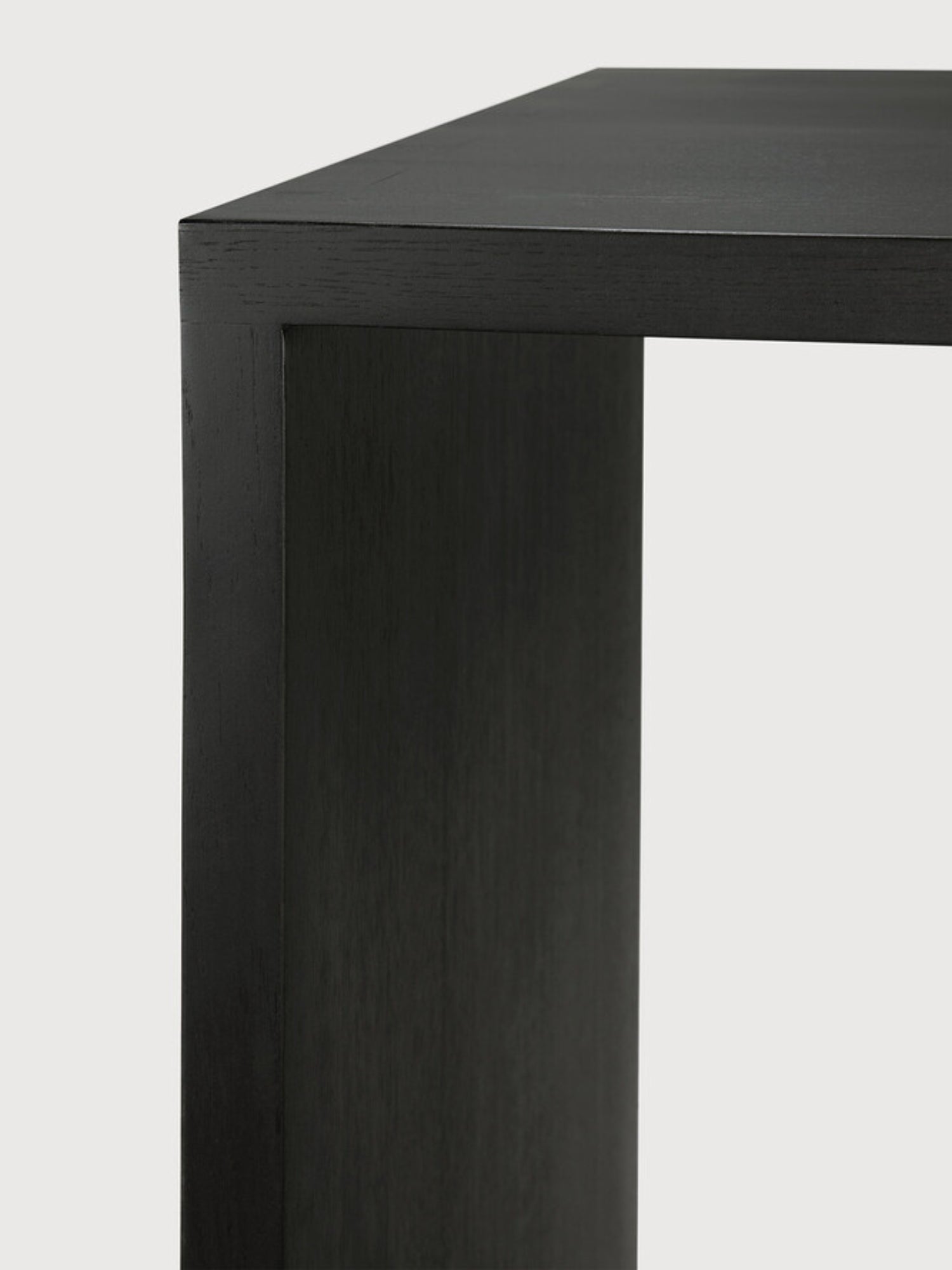 Ethnicraft U Desk, a modern black oak desk, showcasing a close-up of its sleek, dark wooden corner and sturdy construction, displayed on a clean white background.