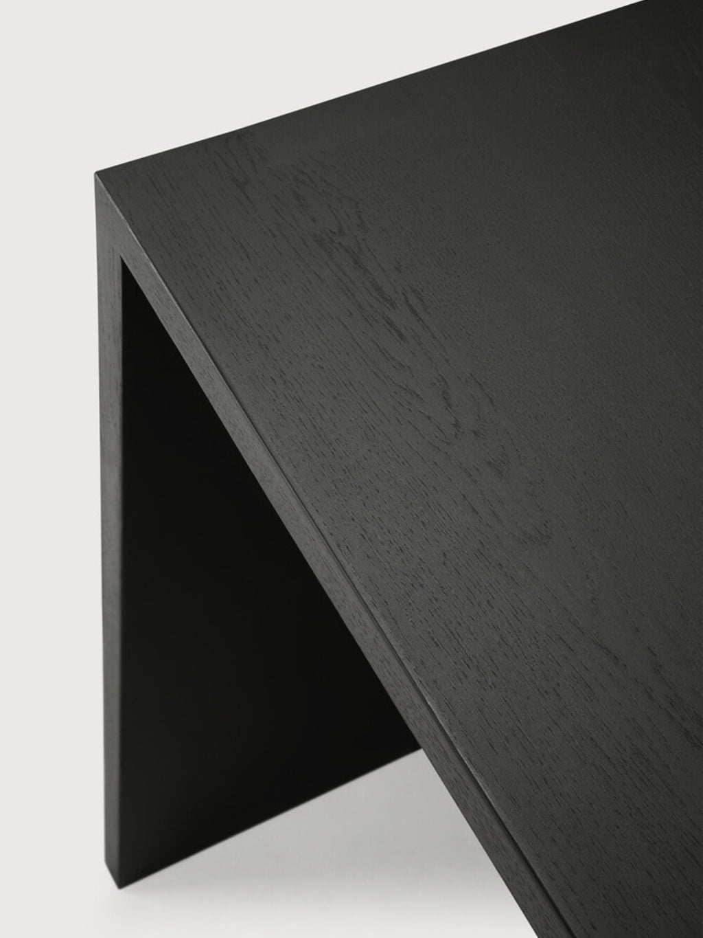 Ethnicraft U Desk in black oak, an angled view showcasing the elegant dark wood grain and the desk's sleek, minimalist U-shaped profile, perfect for modern interiors.