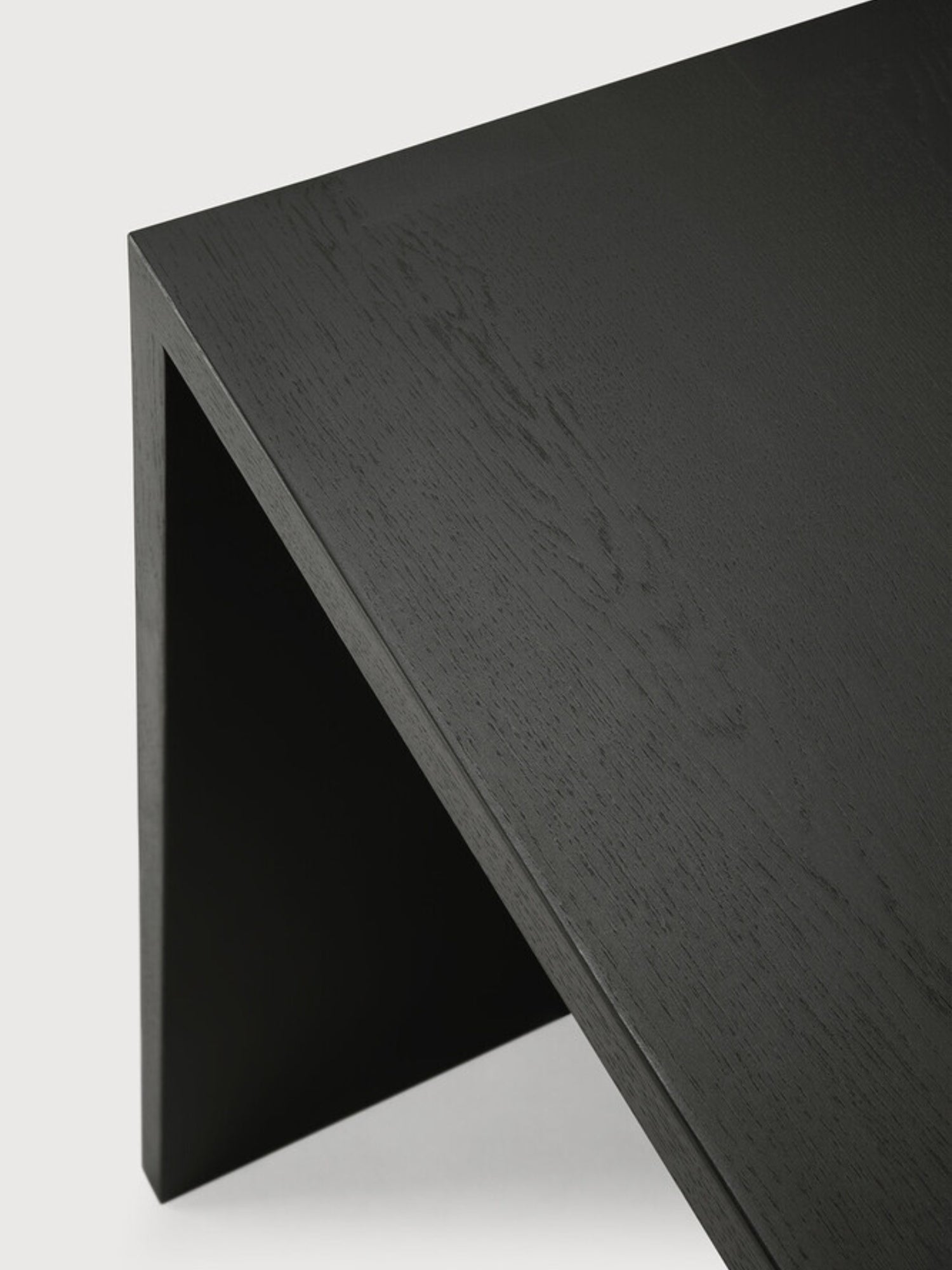 Ethnicraft U Desk in black oak, an angled view showcasing the elegant dark wood grain and the desk's sleek, minimalist U-shaped profile, perfect for modern interiors.