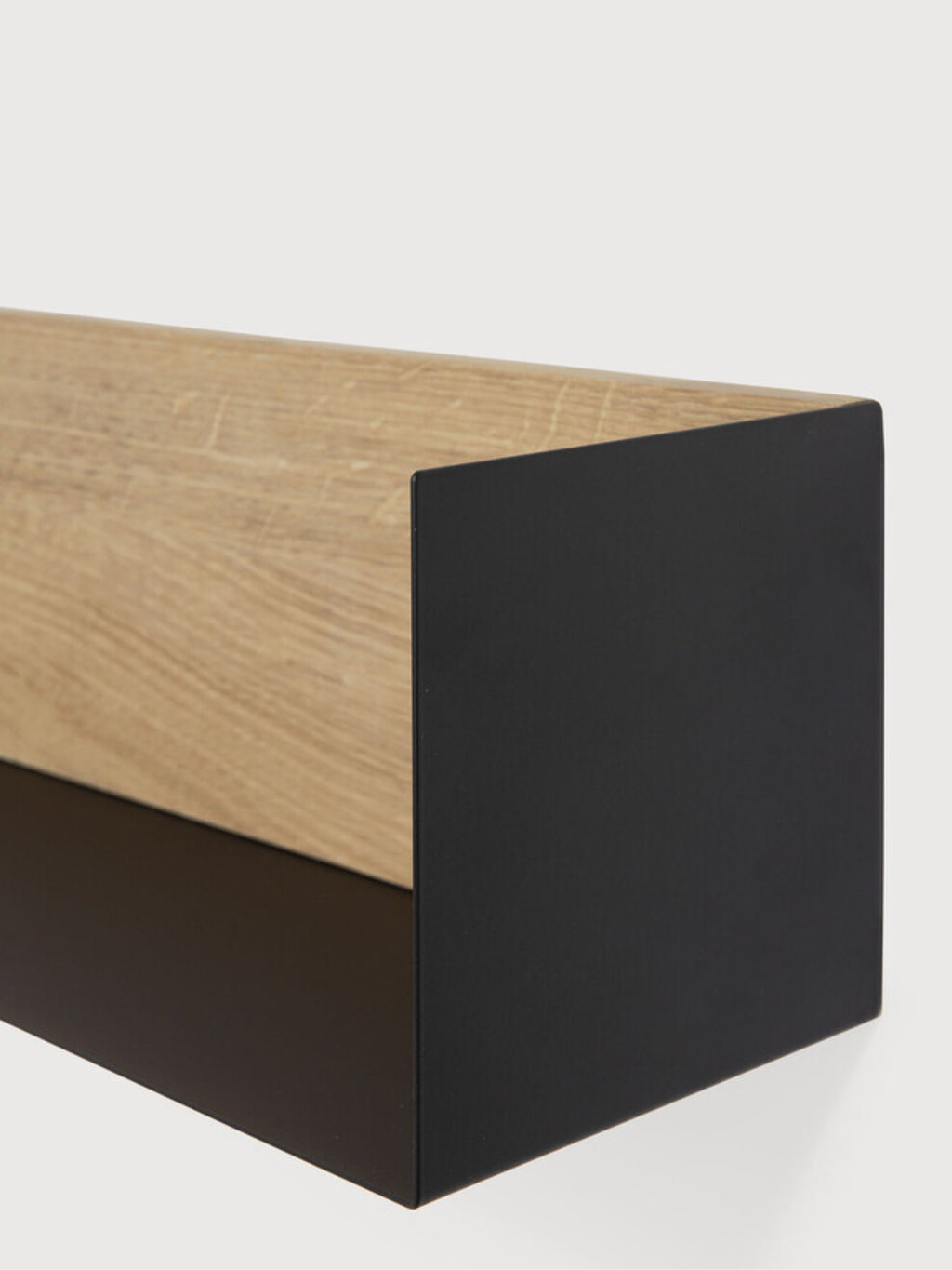 Ethnicraft U Shelf, a modern minimalist floating wall shelf featuring a natural light oak wood top and back with visible grain, contrasted by a sleek matte black metal base and side panel, forming a distinct U-shaped profile. This contemporary wood and metal shelf is perfect for adding industrial chic storage or Scandinavian style decor to living rooms, bedrooms, or home offices.