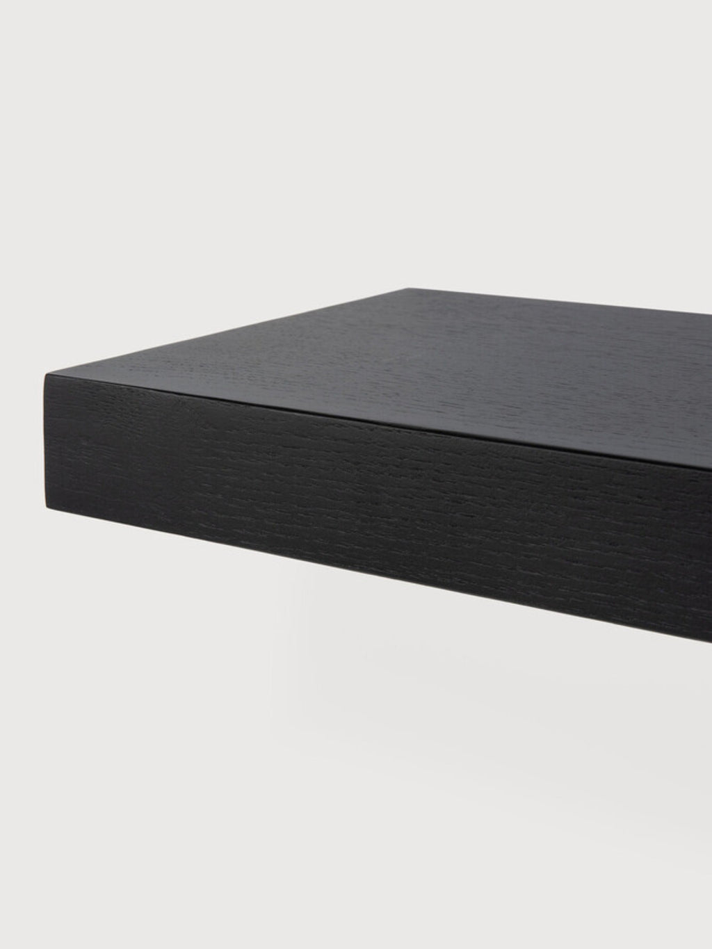 Ethnicraft Wall Shelf, a sleek modern minimalist floating shelf crafted from black stained solid oak with a subtle, textured wood grain finish. Its clean, rectilinear design provides a substantial yet understated display surface for contemporary interiors. Ideal for sophisticated storage in living rooms, bedrooms, or home offices.