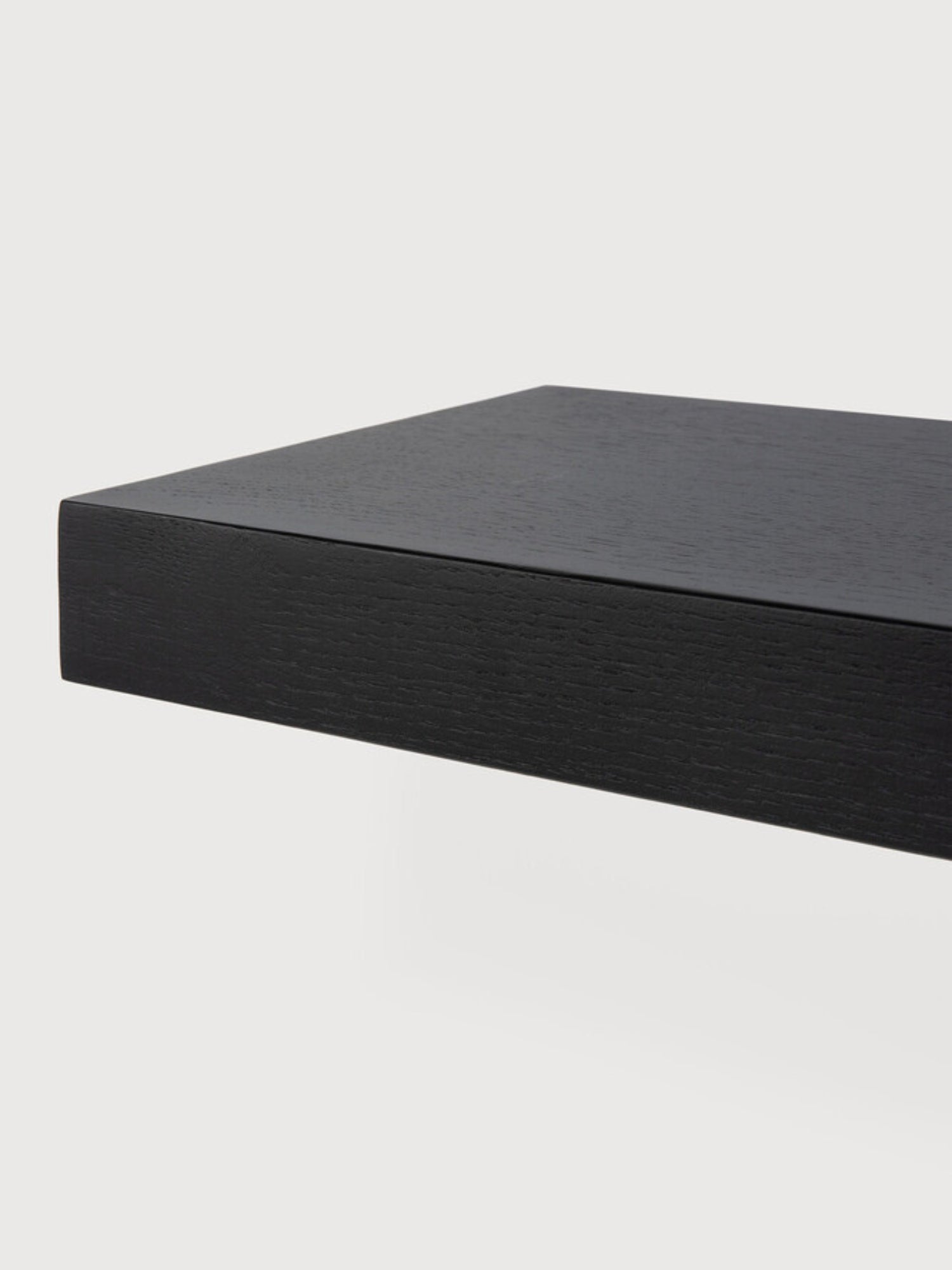 Ethnicraft Wall Shelf, a sleek modern minimalist floating shelf crafted from black stained solid oak with a subtle, textured wood grain finish. Its clean, rectilinear design provides a substantial yet understated display surface for contemporary interiors. Ideal for sophisticated storage in living rooms, bedrooms, or home offices.