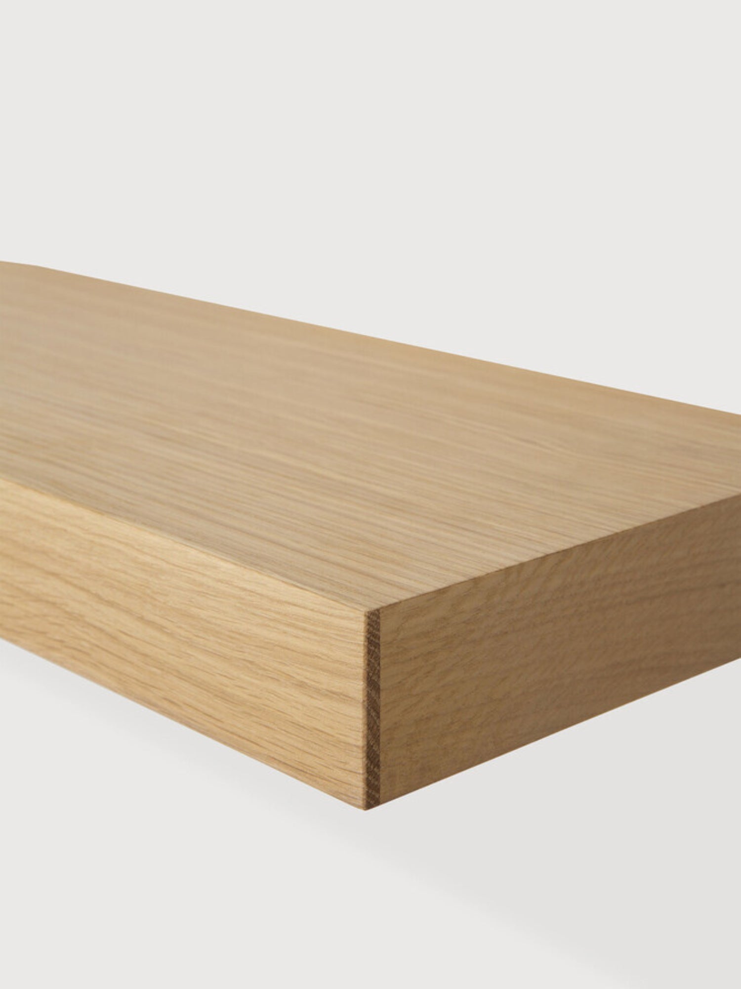 Ethnicraft Wall Shelf, a thick modern minimalist floating shelf crafted from natural solid oak wood, showcasing a smooth texture, visible grain, and warm light brown tones with clean, contemporary lines. Perfect for versatile shelf styling in Scandinavian living rooms, bedrooms, or home offices.