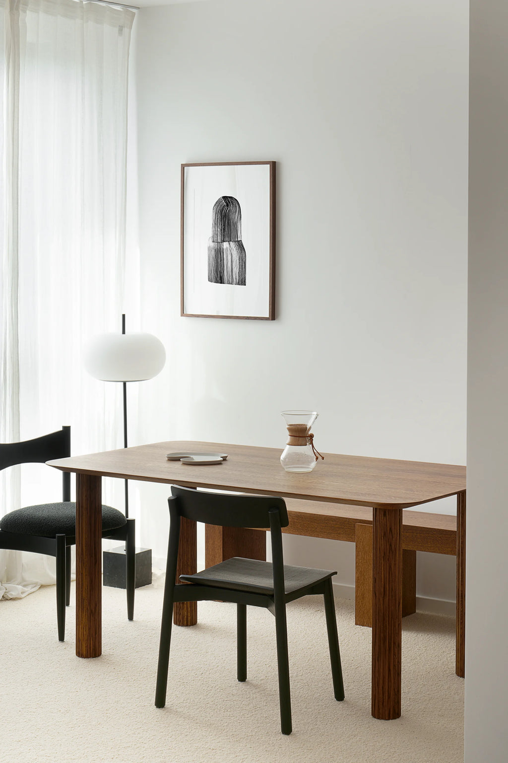 TAMO Filar Dining Table in a lifestyle setting, showcasing its warm brown wood grain finish, rounded edges, and modern design. Perfect for a contemporary dining space.
