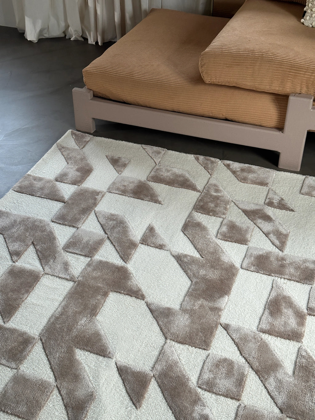 Tinted Objects Franzen Rug, a modern tufted area rug with a stylish geometric pattern in varying shades of cream and taupe, featuring plush, soft textures. This luxurious floor covering is perfect for adding warmth and contemporary elegance to any living room or bedroom decor.