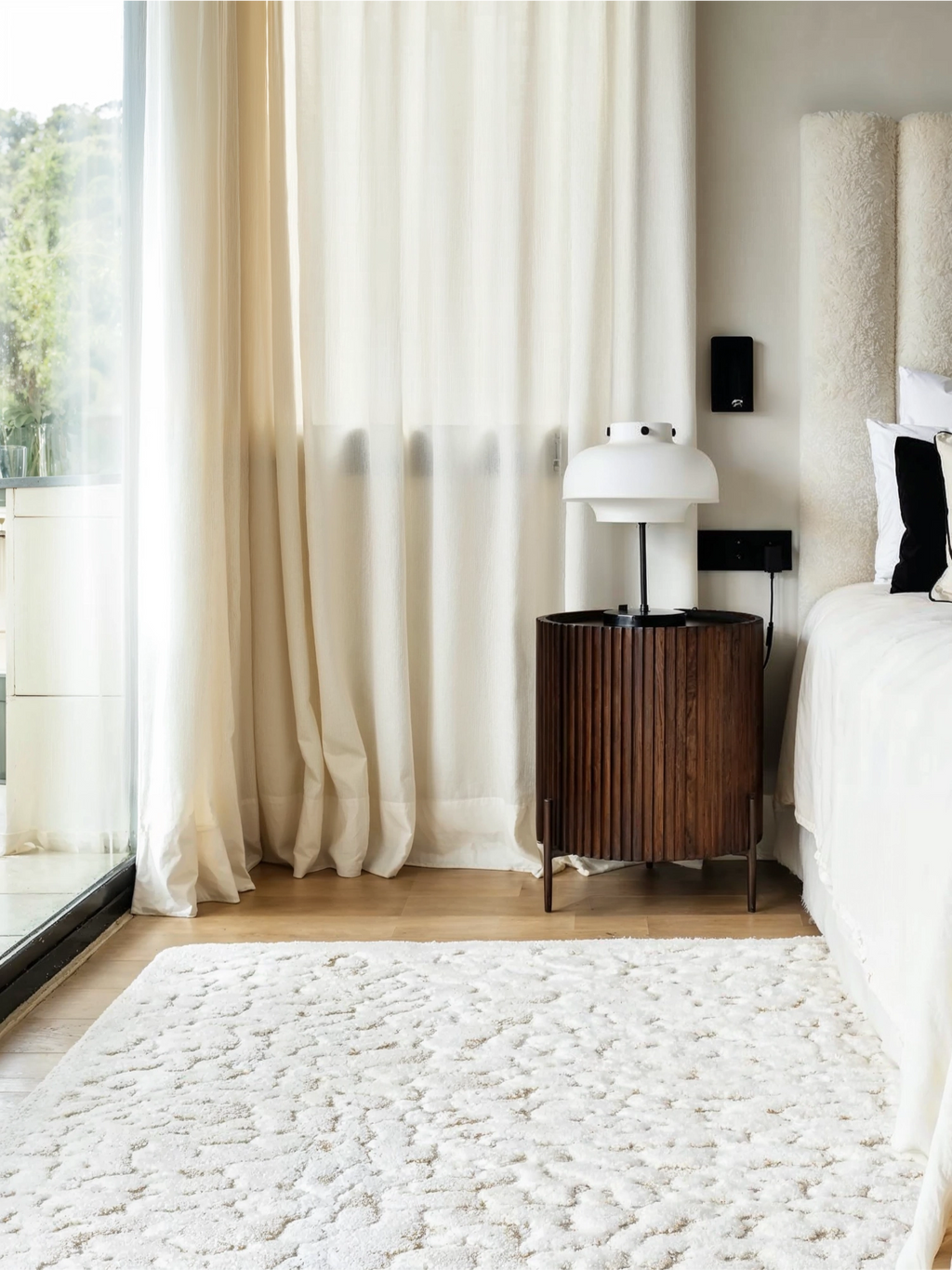 alp_ Borneo Rug, a luxurious cream-colored area rug featuring a plush, high-pile shaggy texture with an organic, cloud-like pattern in natural undyed tones. This soft wool rug provides immense comfort and visual depth, making it an inviting centerpiece for any room. Ideal for a cozy minimalist bedroom, organic modern living room, or a Scandinavian-inspired interior seeking warmth and sophisticated texture.
