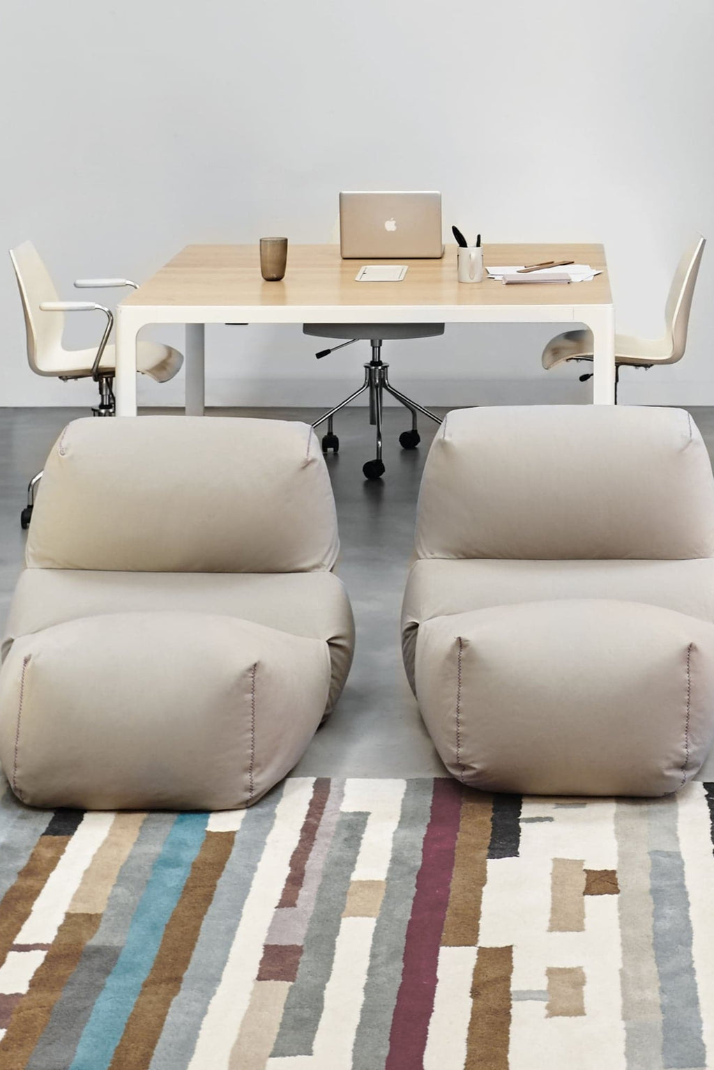 GAN Rugs Grapy Lounge Chair, a modern minimalist floor chair designed with a relaxed, organic silhouette and plush light beige fabric upholstery, accented by distinctive visible stitching details.