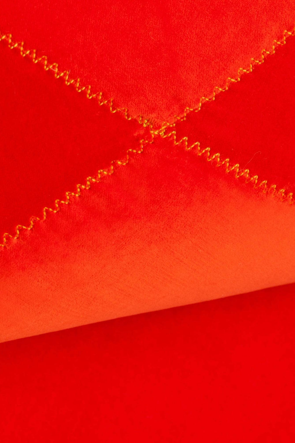 GAN Rugs Grapy Lounge - Velvet, a plush, vibrant red-orange velvet lounge chair featuring distinctive yellow zigzag stitching that creates a playful quilted pattern on its soft upholstery.