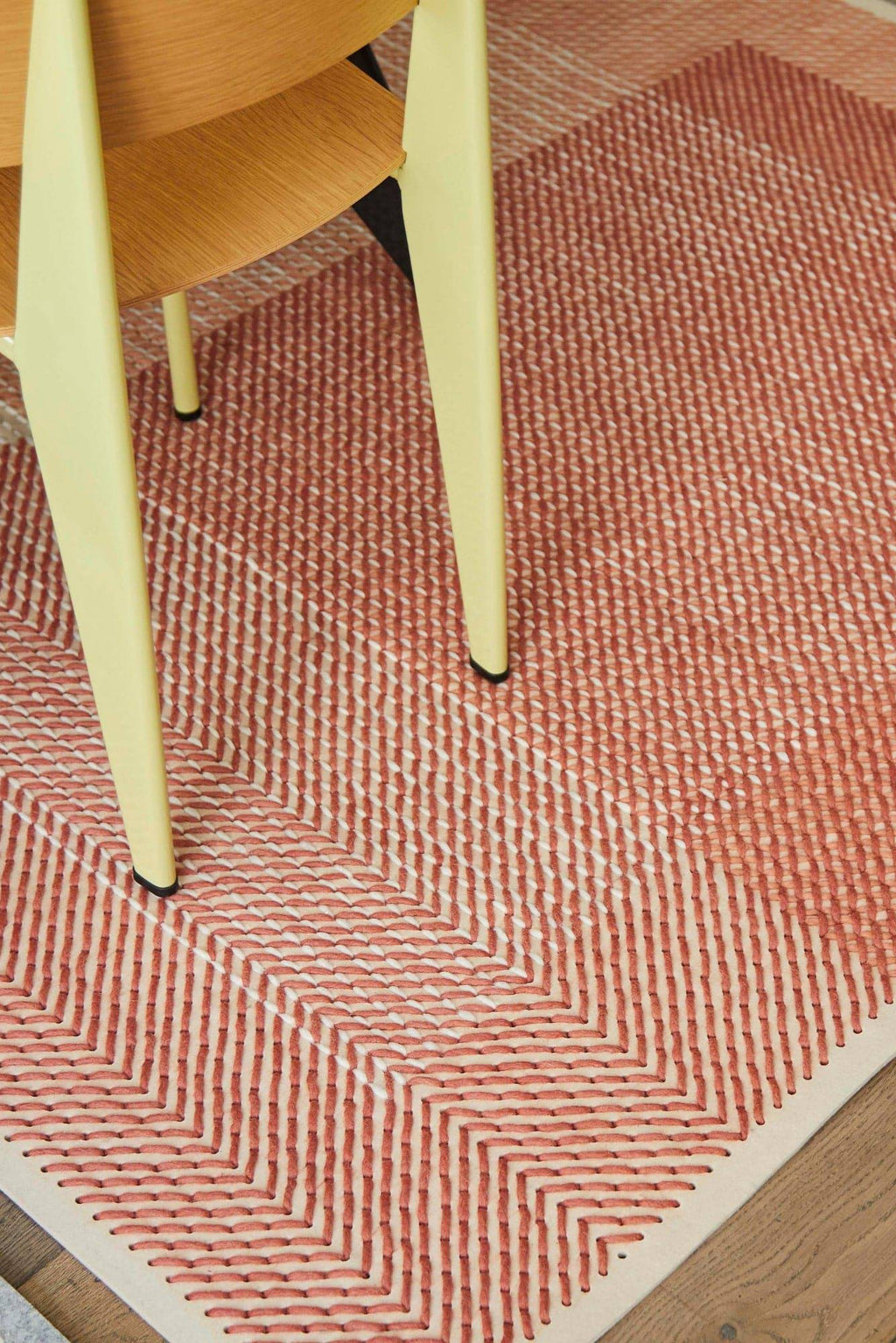 GAN Rugs Canevas Geo Rug, a striking hand-embroidered area rug featuring a bold geometric chevron pattern in rich terracotta and cream tones, crafted with a distinctive chunky stitch texture.