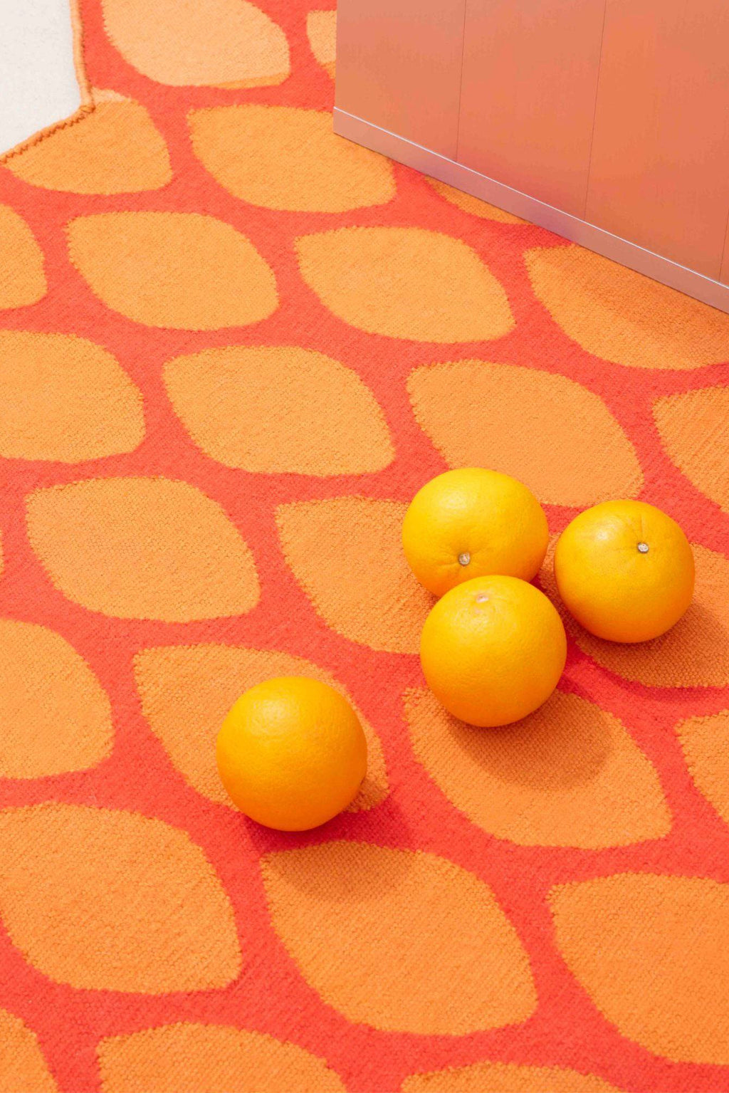 GAN Rugs Citrus Outdoor Rug, a vibrant mid-century modern area rug featuring a bold organic leaf-like pattern in bright orange and coral red, crafted from a durable weather-resistant woven.
