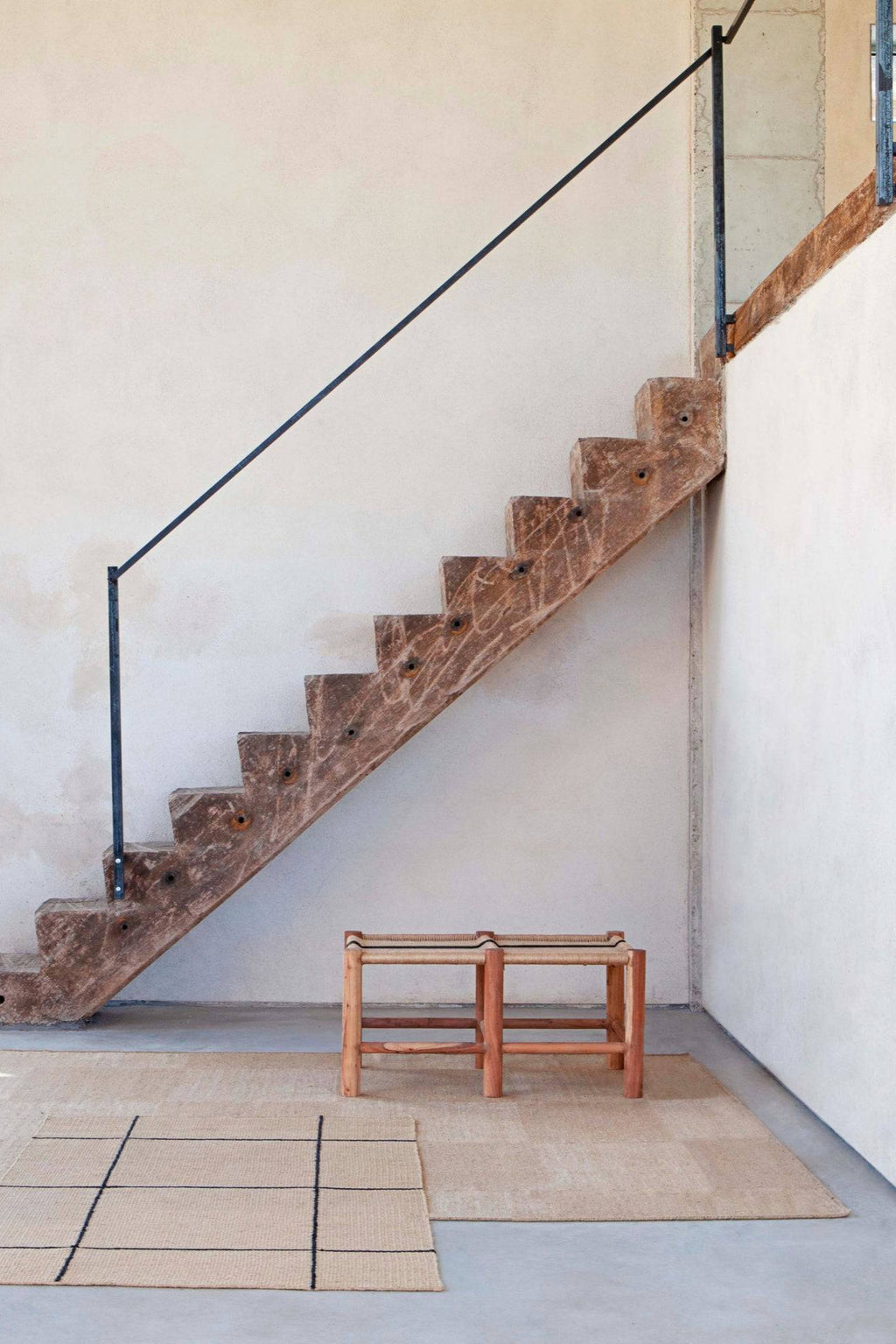 GAN Rugs Roots 01 Stool, a handcrafted rustic modern stool featuring a sturdy natural wood frame with visible grain and a flat, rectangular woven seat in natural beige fibers accented with thin black lines.
