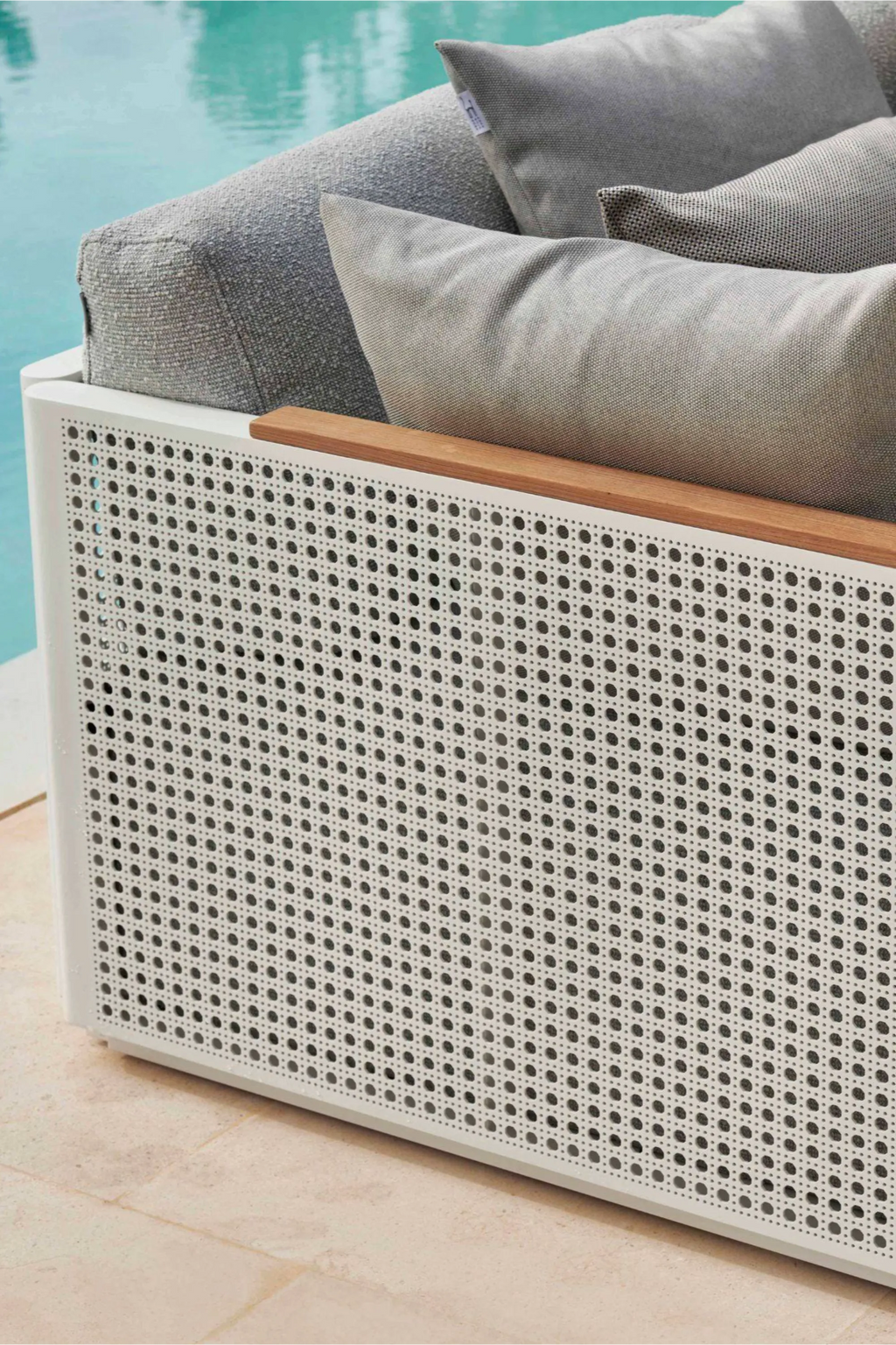 Gandia Blasco Bosc Sectional 2, a modern minimalist outdoor sofa module featuring a sleek white aluminum frame with a distinctive perforated metal panel design mimicking traditional cane weaving, complemented by a warm natural teak wood armrest detail. It includes plush grey upholstered outdoor cushions with a durable textured fabric for ultimate comfort and resilience. This contemporary outdoor lounge seating is ideal for luxury patio areas, pool decks, or modern garden spaces.