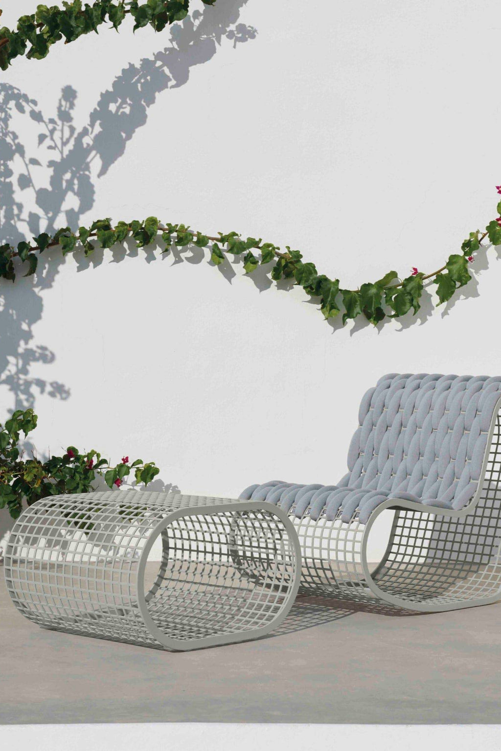 Gandia Blasco Buit Pouf, a modern outdoor pouf featuring a light grey grid-patterned aluminum base with a curved cylindrical shape and architectural design, topped by a plush light.