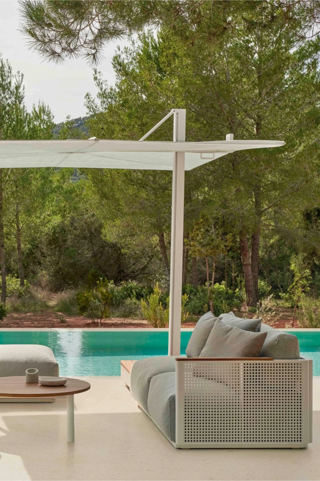 Gandia Blasco Bosc Sectional 1, a modern outdoor sectional sofa featuring a crisp white perforated aluminum frame with warm natural wood armrest details and plush light grey upholstered cushions. This contemporary patio lounge furniture piece is perfectly designed for poolside relaxation or elegant outdoor living spaces.