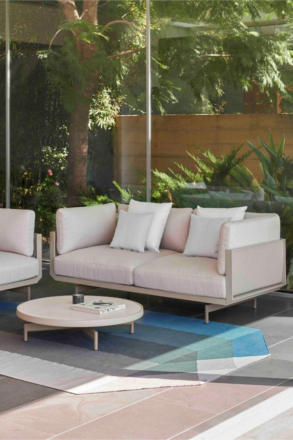 Gandia Blasco Onde Round Coffee Table Ø90, a modern minimalist outdoor coffee table featuring a smooth, matte light cream tabletop atop a sturdy powder-coated aluminum frame with elegant cylindrical legs in a complementary beige finish. This contemporary round patio table is ideal for stylish outdoor living rooms, garden lounges, and modern poolside areas.
