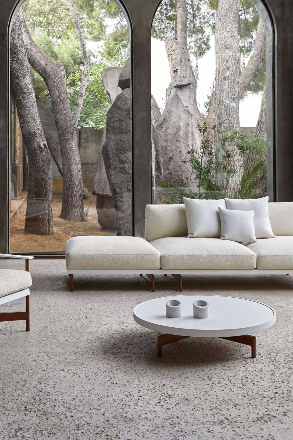 Gandia Blasco Onde Round Coffee Table Ø90, a modern minimalist outdoor coffee table featuring a clean matte white aluminum tabletop with a sleek round silhouette. Its warm brown, thermally treated wood-effect aluminum legs provide a subtle organic contrast and contemporary appeal. Ideal for a sophisticated outdoor living room or stylish patio area.