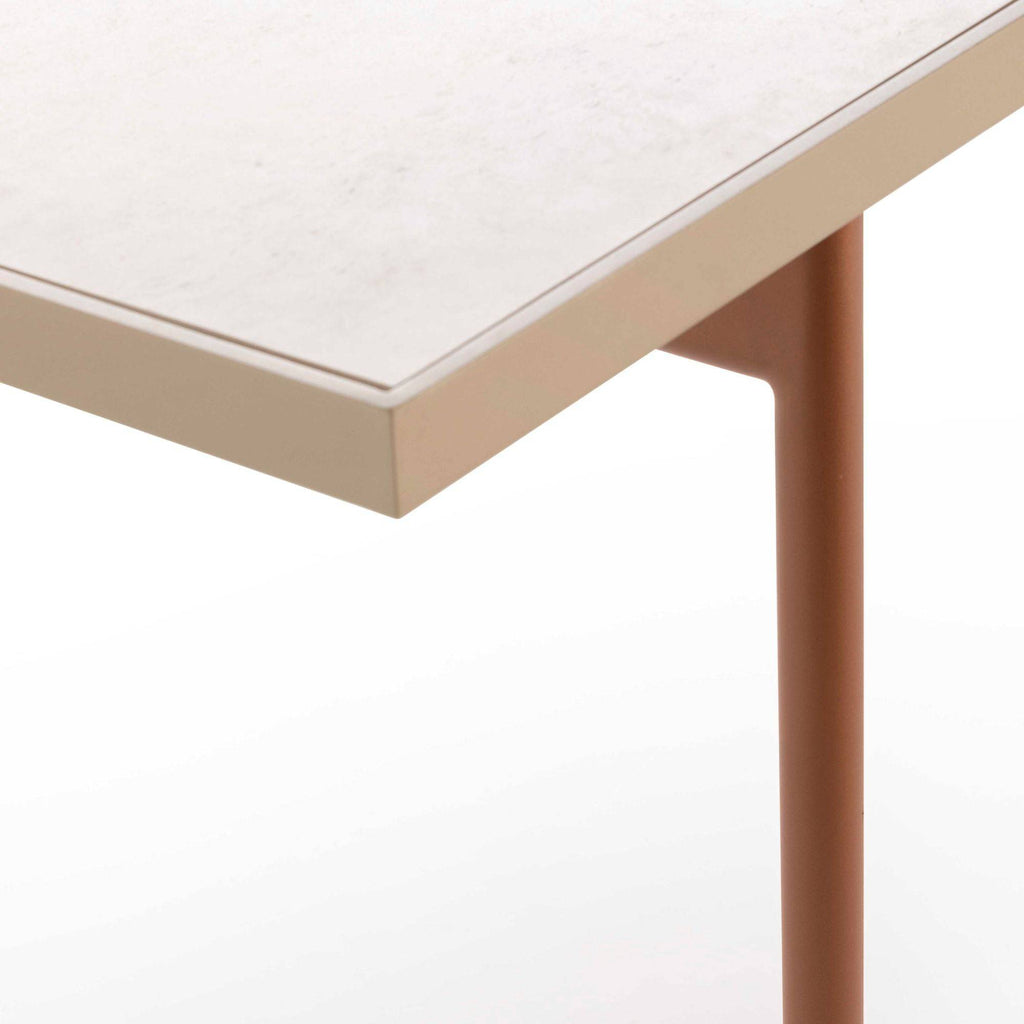 Gandia Blasco Onde Dining Table, a modern minimalist outdoor dining table featuring a light beige textured composite tabletop and sturdy matte terracotta powder-coated aluminum legs with a sleek, contemporary design.
