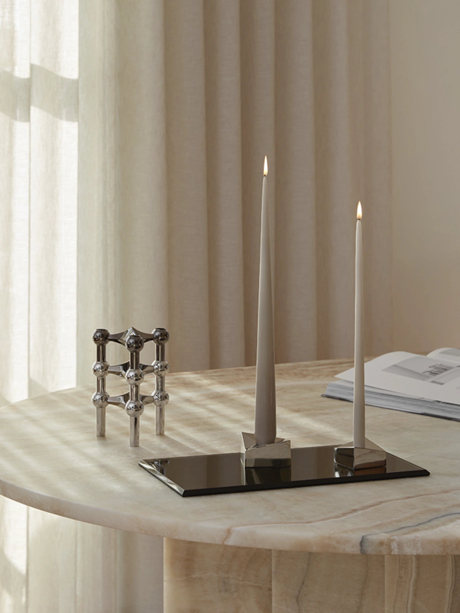 Large taper candle and taper candle in white and off white for elegant home decor. Chrome and stainless steel color Stoff nagel candle holders.