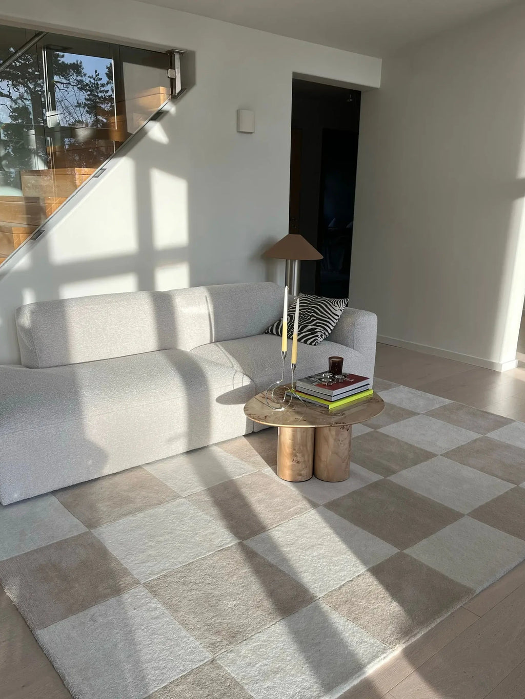 Tinted Objects Hafstrom Wool Rug, featuring a checkerboard pattern in alternating light beige and cream squares, with a soft, plush texture. This high-quality, modern area rug is perfect for adding warmth and sophisticated style to a contemporary living room.