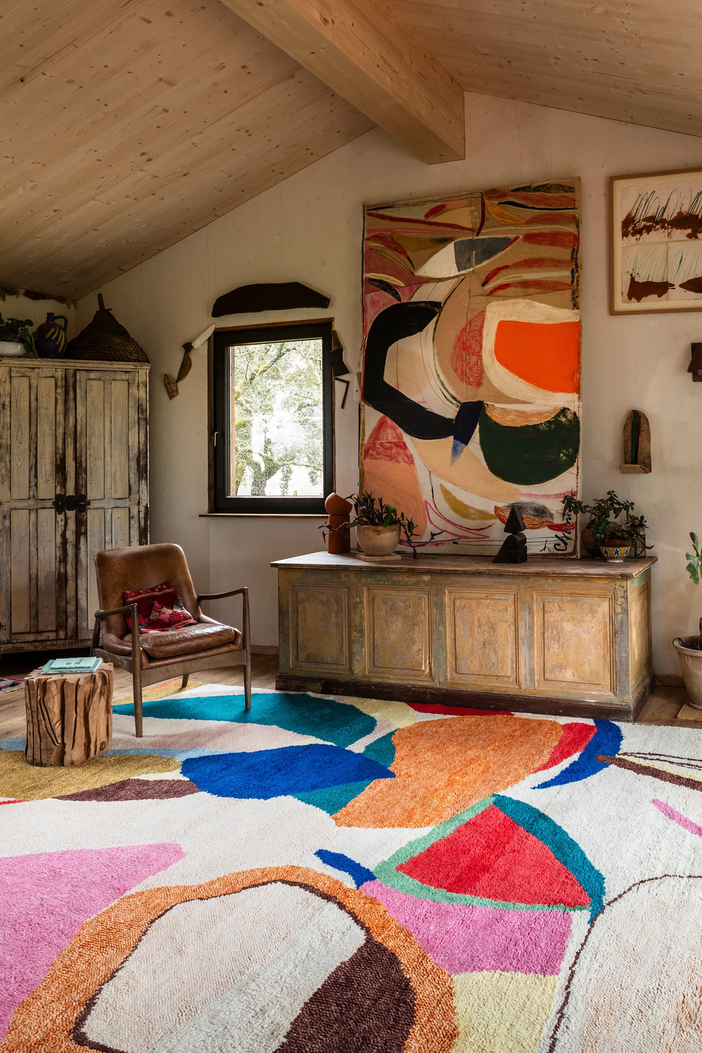 Layered Kaleidoscope Wool Rug, a vibrant multicolored abstract wool rug with bold shapes in blue, orange, pink, red, and green on an off-white background. Perfect for adding a playful, artistic tou...