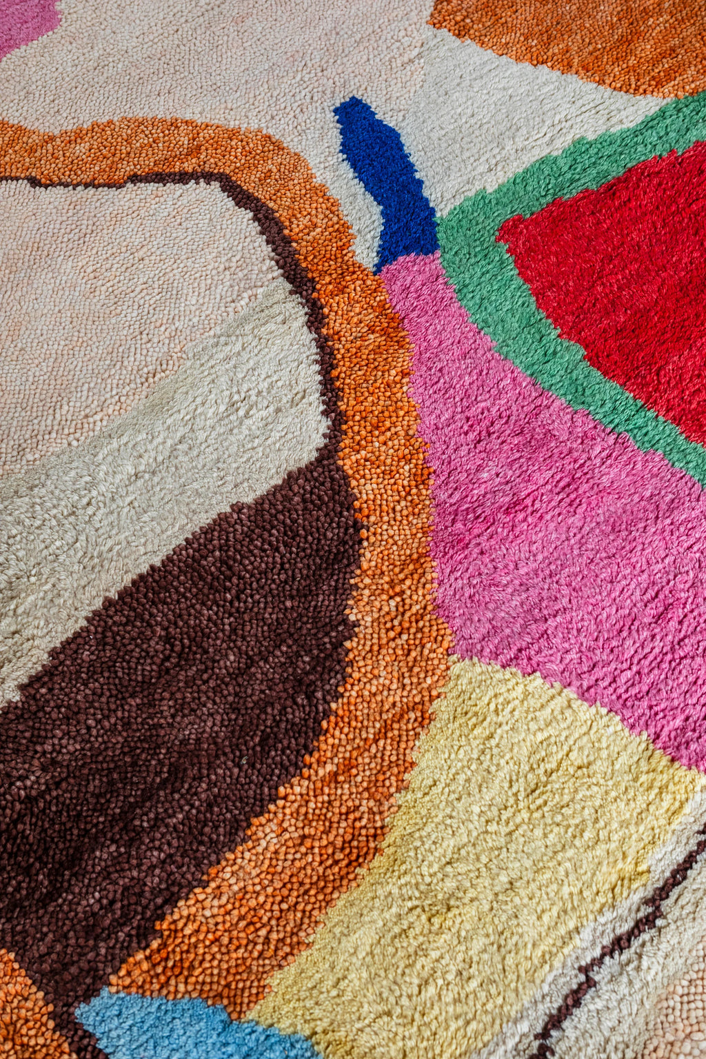 Layered Kaleidoscope Wool Rug featuring a vibrant, abstract pattern with thick, textured loops in shades of pink, red, blue, green, orange, brown, and cream. Perfect for adding a playful, modern po...