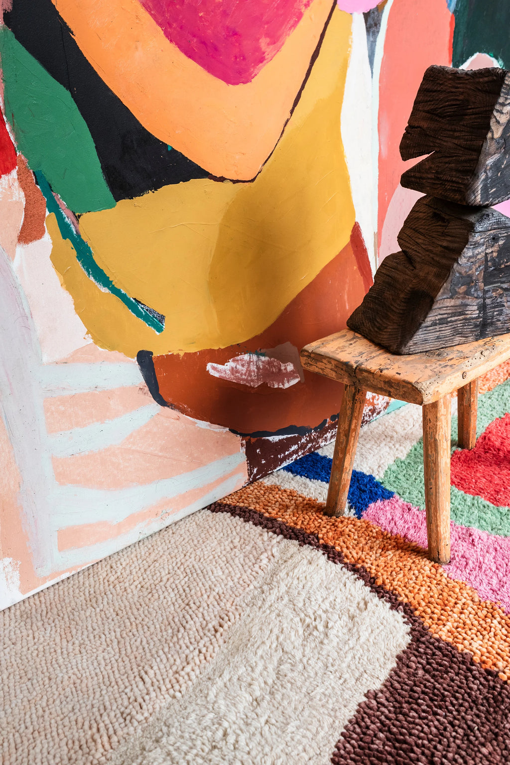 Layered Kaleidoscope Wool Rug, a vibrant, multicolored shag rug with thick pile texture in shades of white, brown, orange, pink, blue, and green. Perfect for adding a playful, colorful accent to an...