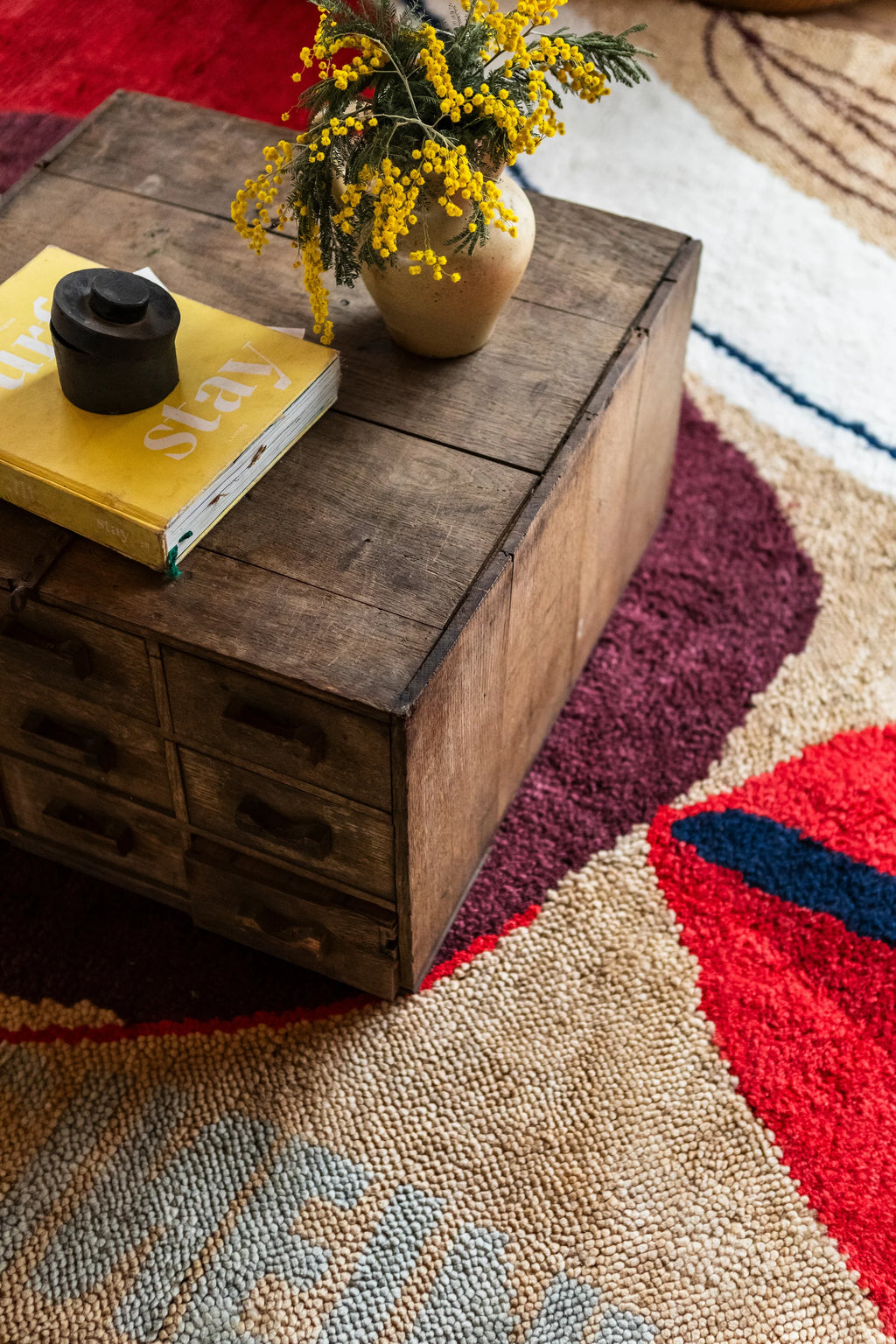 Layered Collage Wool Rug, a vibrant modern area rug with abstract shapes in red, beige, blue, and burgundy tones, featuring a textured wool pile. Perfect for adding a colorful statement to any cont...