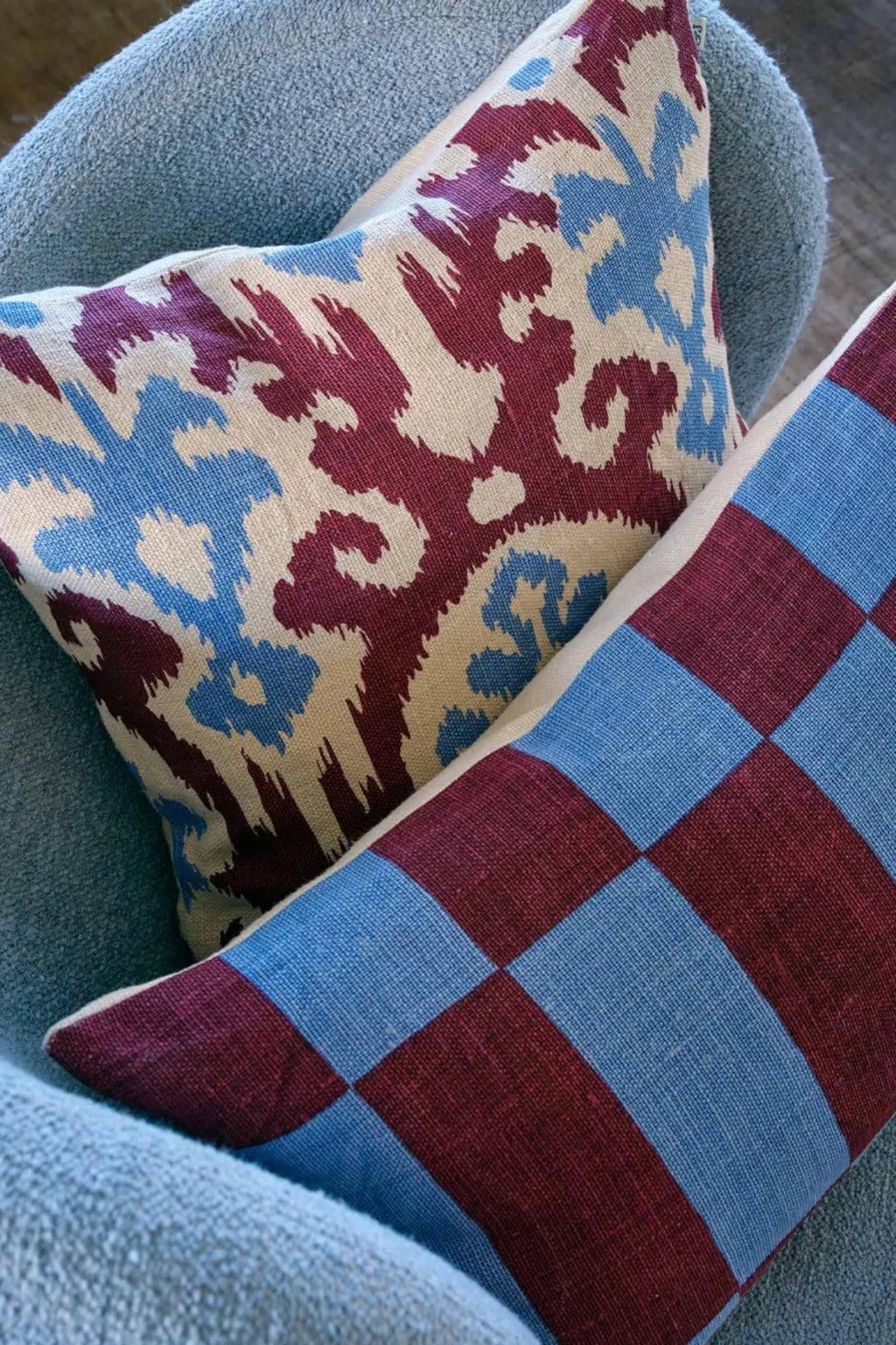 Chhatwal & Jonsson Samar Linen Throw Pillow, an eclectic collection of handwoven linen cushions featuring a vibrant burgundy, sky blue, and natural beige ikat pattern alongside a bold checkered design. These decorative pillows add global-inspired texture and rich color to any space. Perfect for styling modern living rooms, boho bedrooms, or cozy reading nooks.