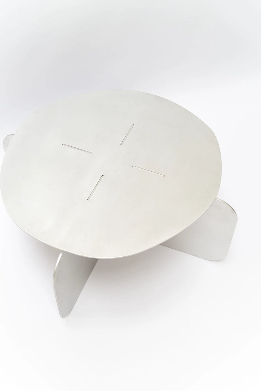 NG DESIGN Object 105 Coffee Table, a minimalist, round brushed aluminum coffee table with four leg panels intersecting the tabletop. Ideal for modern living spaces.