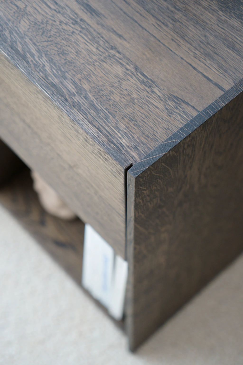 TAMO Kari Nightstand, close-up of premium dark brown oak wood grain with distinct linear textures and mitered joints. This luxury furniture blends seamlessly into modern bedroom decor.