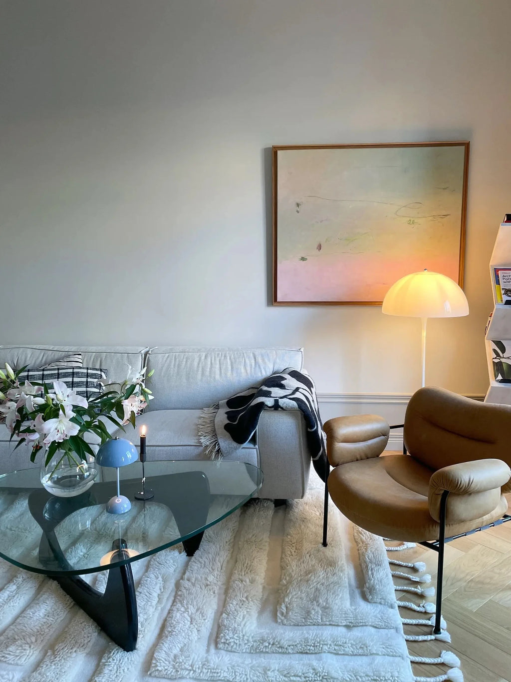 Tinted Objects Kask Wool Rug, a plush, off-white shag rug featuring varying pile heights and decorative braided tassels. This luxurious, soft rug is perfect for adding warmth and texture to a modern living room or bedroom.