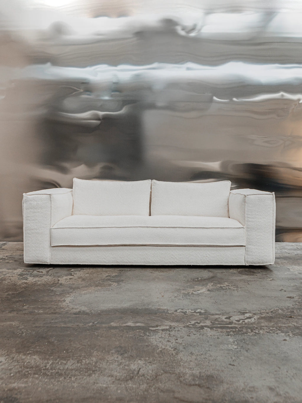 Tinted Objects Klinge Sofa, a modern off-white bouclé fabric sofa with clean lines and plush cushions, showcasing a luxurious texture. This stylish, durable sofa is perfect for adding contemporary elegance to a living room or lounge for design-conscious homeowners.