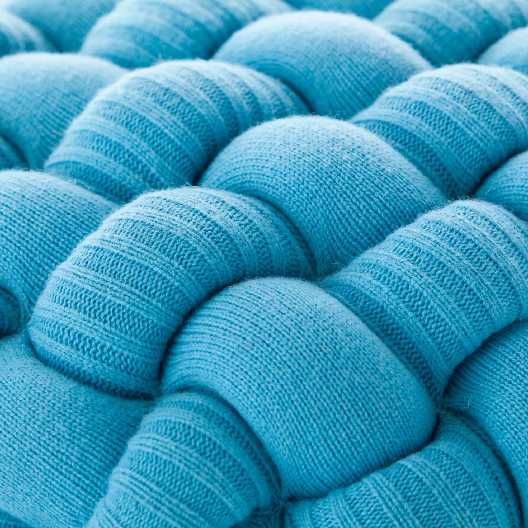 Knitted pouf stool in earthy tones made from high-quality yarn