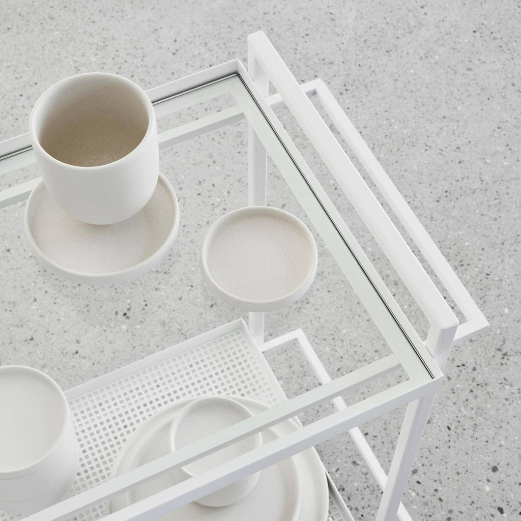 Kristina Dam Setomono Plate S - Set of 4, a collection of four small, round, cream-colored stoneware plates with a subtle speckled matte finish and gently raised edges. These modern minimalist ceramic plates feature an organic, natural texture, reflecting Scandinavian and Japandi design aesthetics. Ideal for appetizers, side dishes, or decorative shelf styling in contemporary dining rooms or living spaces.