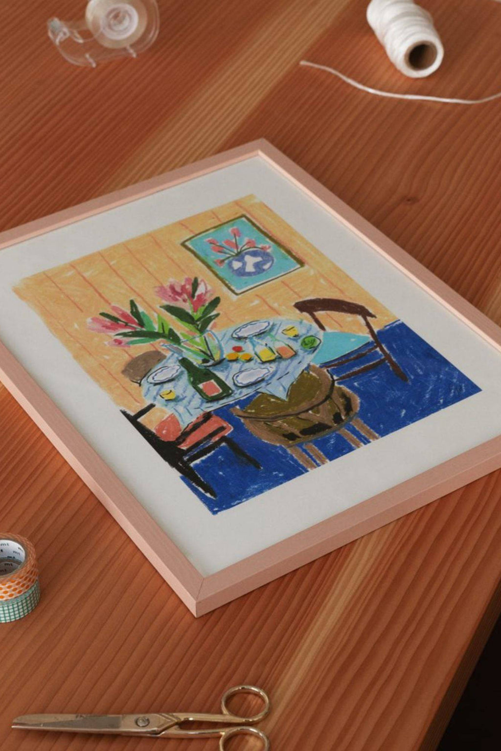The Poster Club Pastel Table, an expressive still life art print featuring a vibrant and colorful dining scene rendered in a charming naive folk art style.