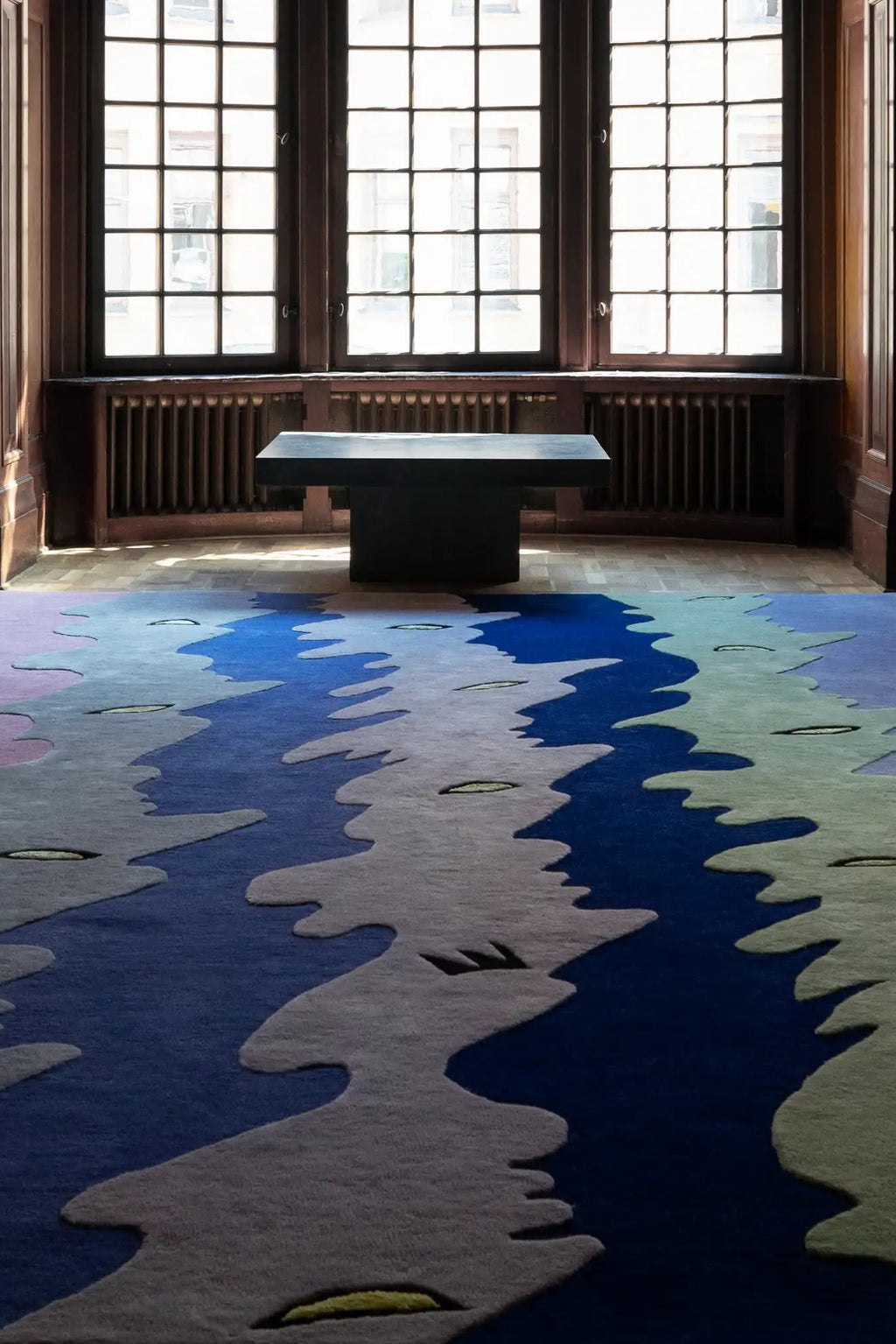 Layered Opera Goers Wool Rug, a vibrant modern area rug with an abstract blue and multi-color wavy pattern, showcasing varied pile heights and textures. Perfect for adding a unique, artistic statem...