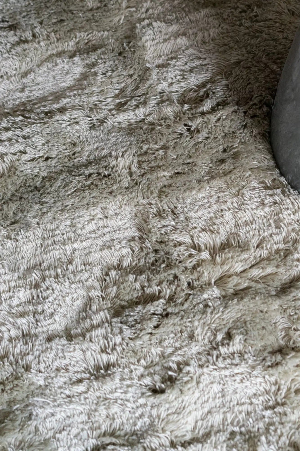 Layered Fallingwater Shaggy Rug, a thick, plush, light beige-grey shaggy area rug with a soft, textured pile. Perfect for adding warmth and comfort to modern living room or bedroom decor.