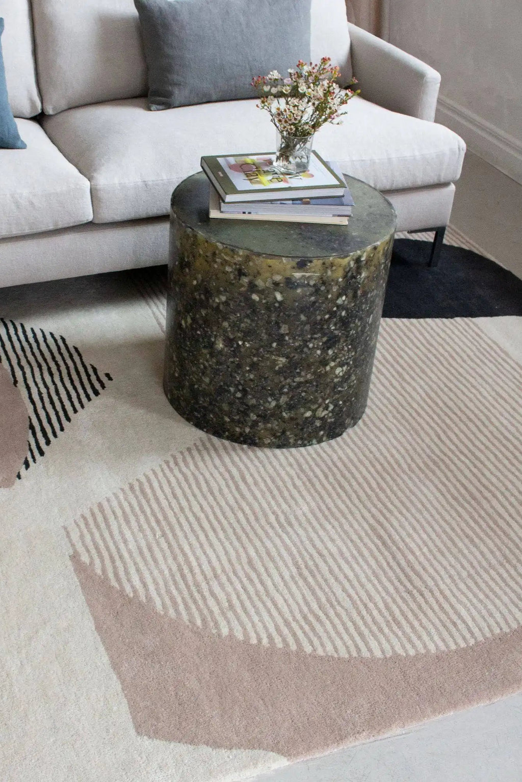 Layered Birch Wool Rug, a modern abstract area rug featuring a pattern of off-white, light beige, and black geometric shapes and stripes. Perfect for adding contemporary style and warmth to living...