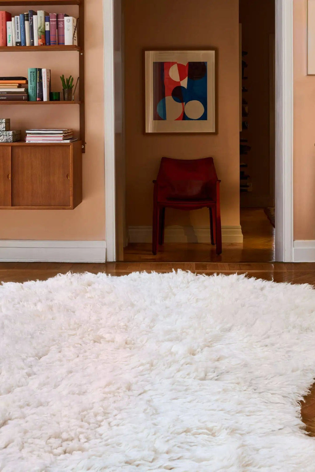 Layered Residue Shaggy Wool Rug, a luxurious off-white natural wool rug with a thick, plush shaggy pile texture, covering a polished hardwood floor. Perfect for adding warmth and softness to any li...