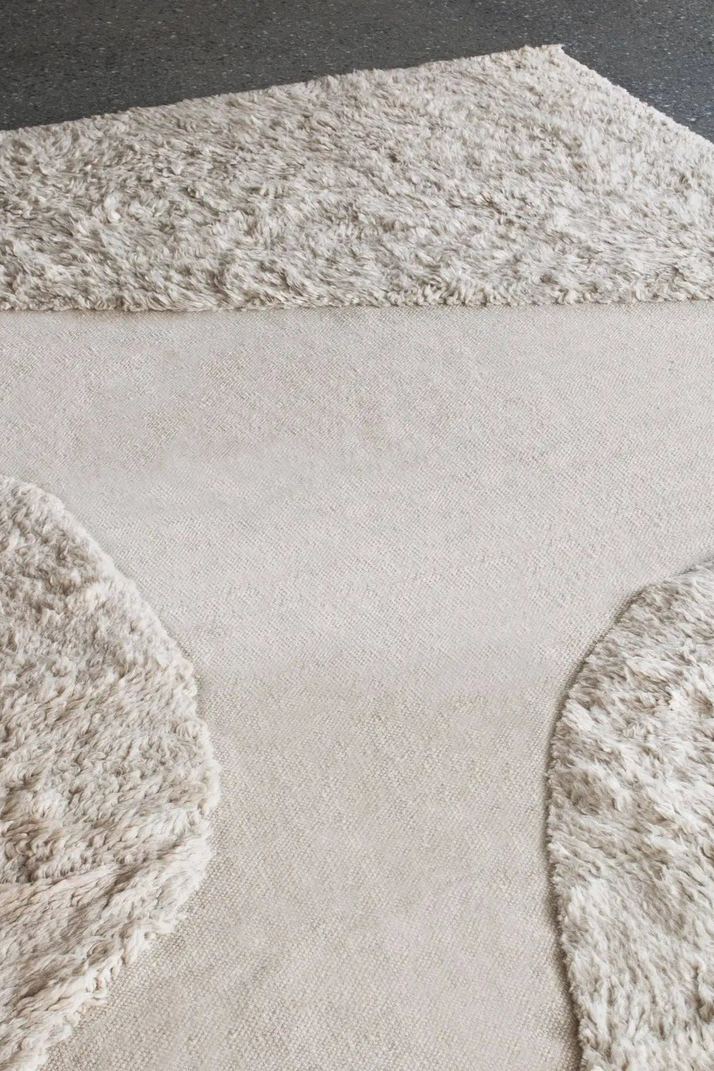 Layered Punja Plasma Wool Rug, a luxurious light beige wool rug with a distinctive cut and loop pile design, featuring plush shaggy sections contrasting with a flat woven base. Perfect for adding t...