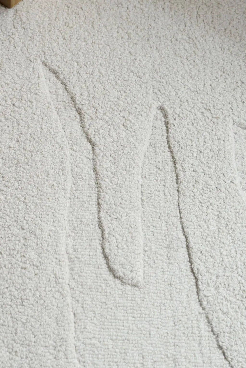 Layered Nami Wool Rug, a premium light gray textured wool area rug with a unique abstract wavy pattern. Perfect for adding modern warmth and comfort to any living space.