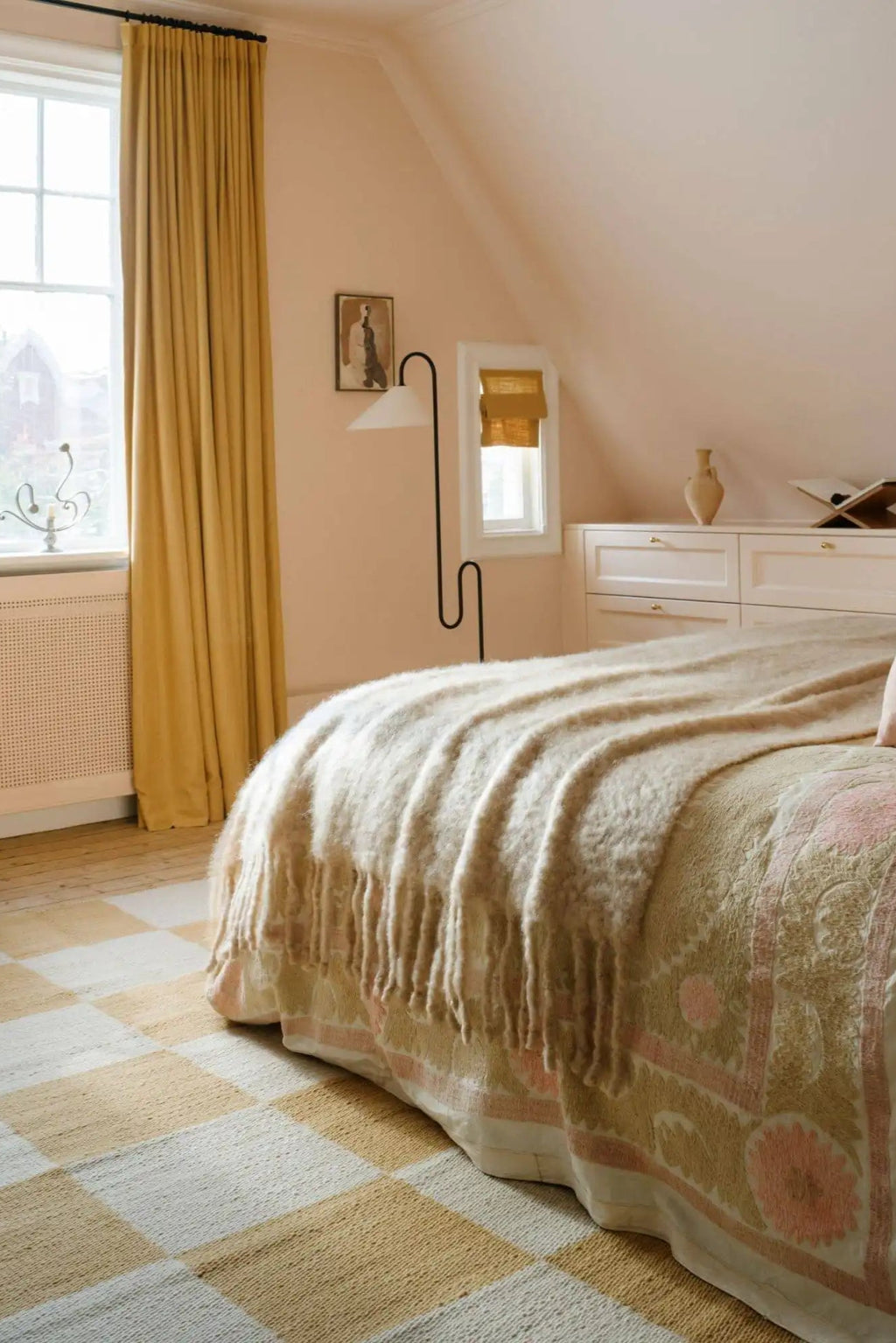Layered Chess Wool Rug, featuring a light tan and off-white checkered pattern, made from soft, durable wool. This stylish area rug adds warmth and modern texture to any bedroom floor.
