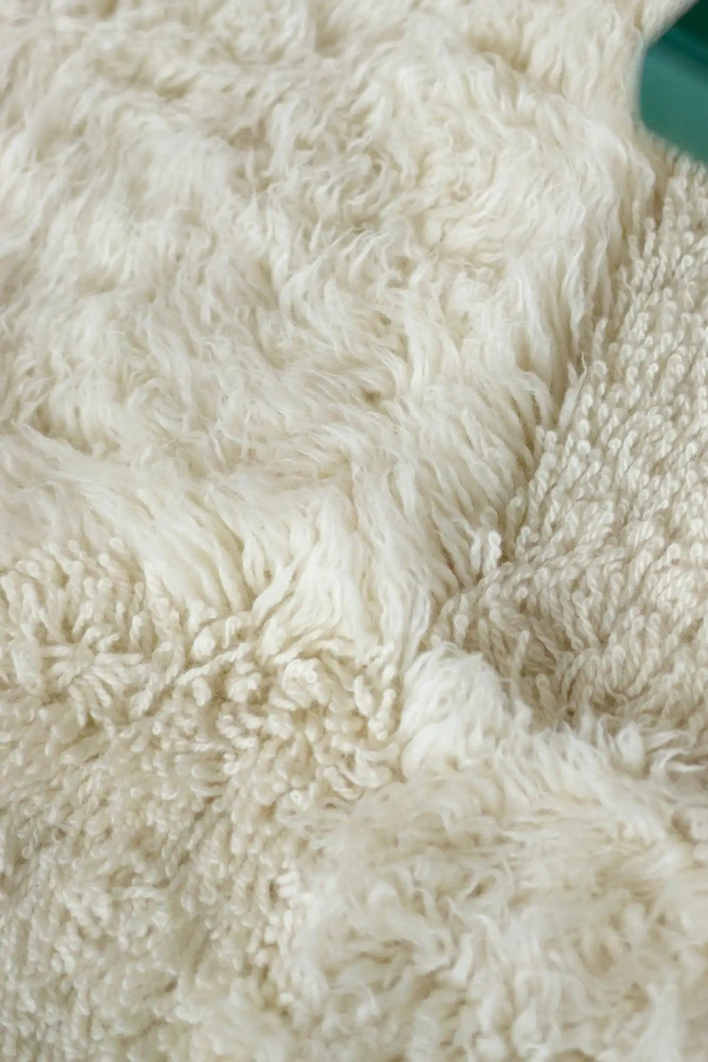 Layered Shaggy Checked Rug, a close-up of the soft, off-white wool fibers showcasing both long shaggy and looped textures. Perfect for adding cozy warmth and modern style to any living space.