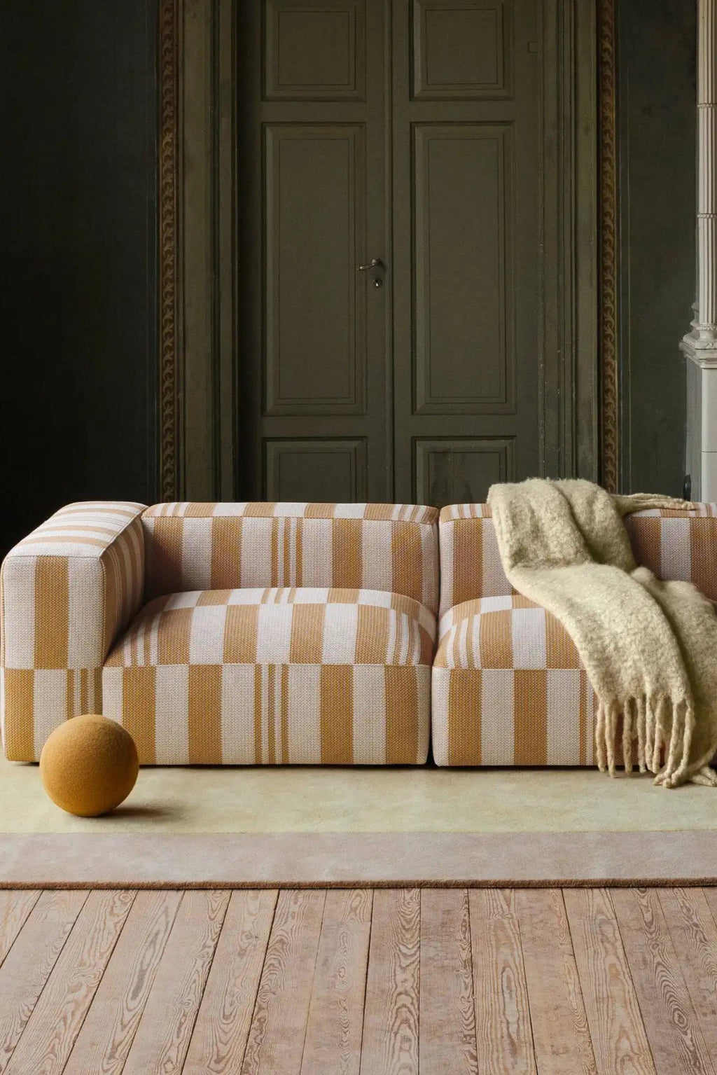 Layered Box Wool Rug, a neutral beige and light yellow wool area rug with a subtle border, providing a soft texture underfoot. Perfect for enhancing the comfort and style of any modern living space.