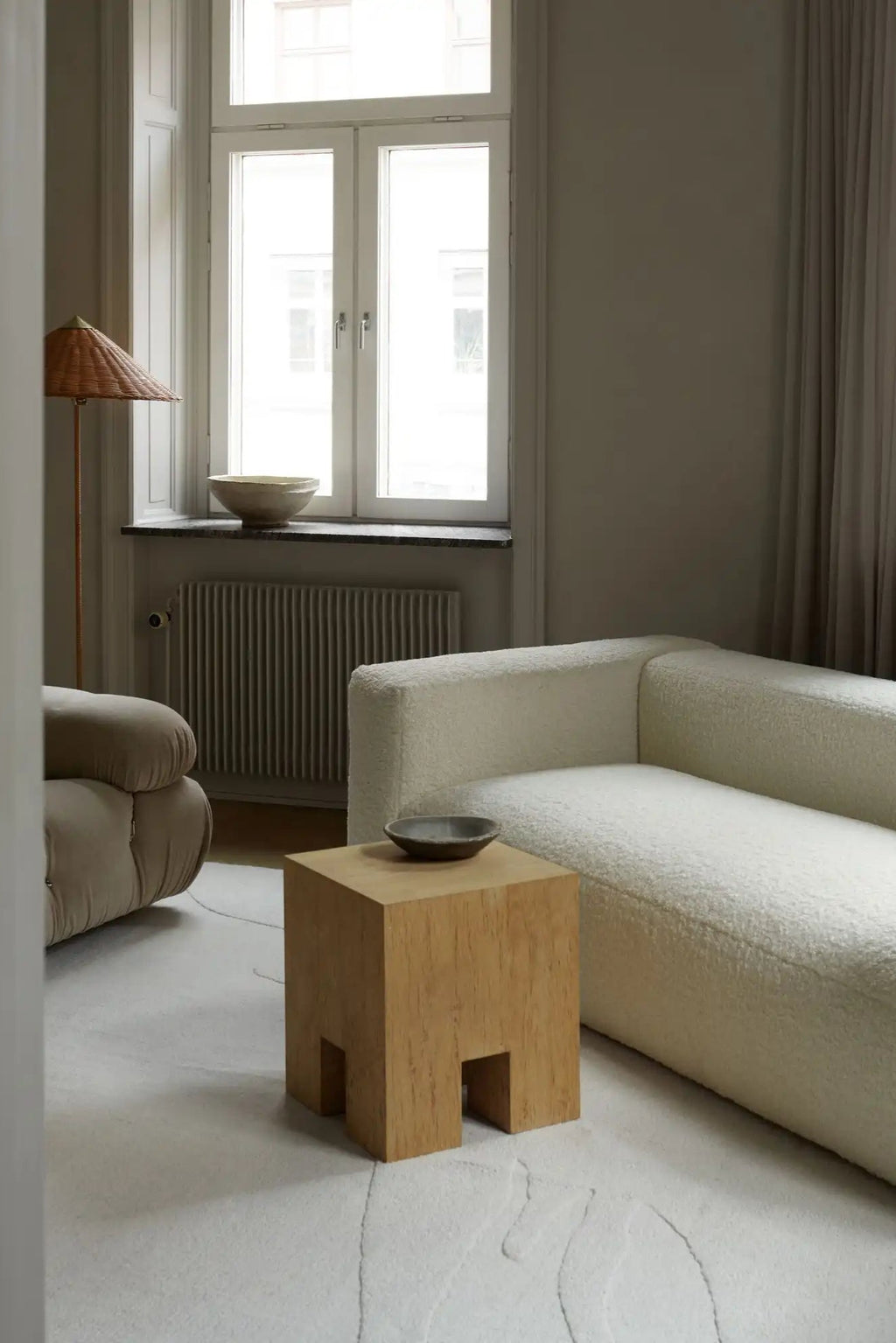 Layered Nami Wool Rug, a light beige, natural wool area rug with subtle, abstract line patterns. Perfect for adding soft texture and modern Scandinavian style to living room spaces.