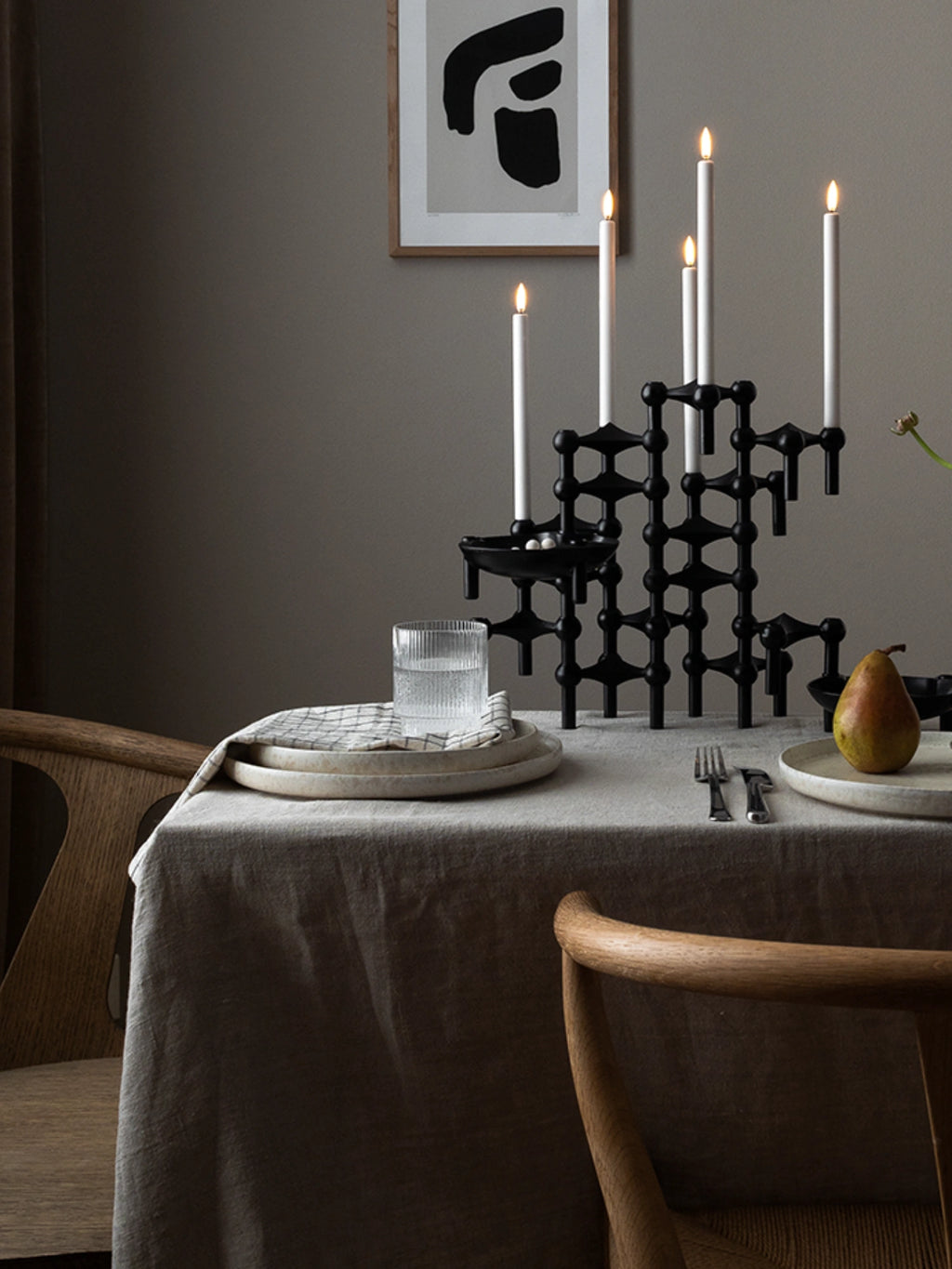 Stoff Nagel LED Candles - Set of 2, featuring a clean white tapered design with a realistic warm yellow flickering flame, offering a safe and modern flameless alternative to traditional wax candles. These battery-operated LED taper candles are perfect for creating a cozy ambiance in Scandinavian dining rooms or as a stylish centerpiece in contemporary living spaces, especially when paired with the iconic Stoff Nagel candelabra.